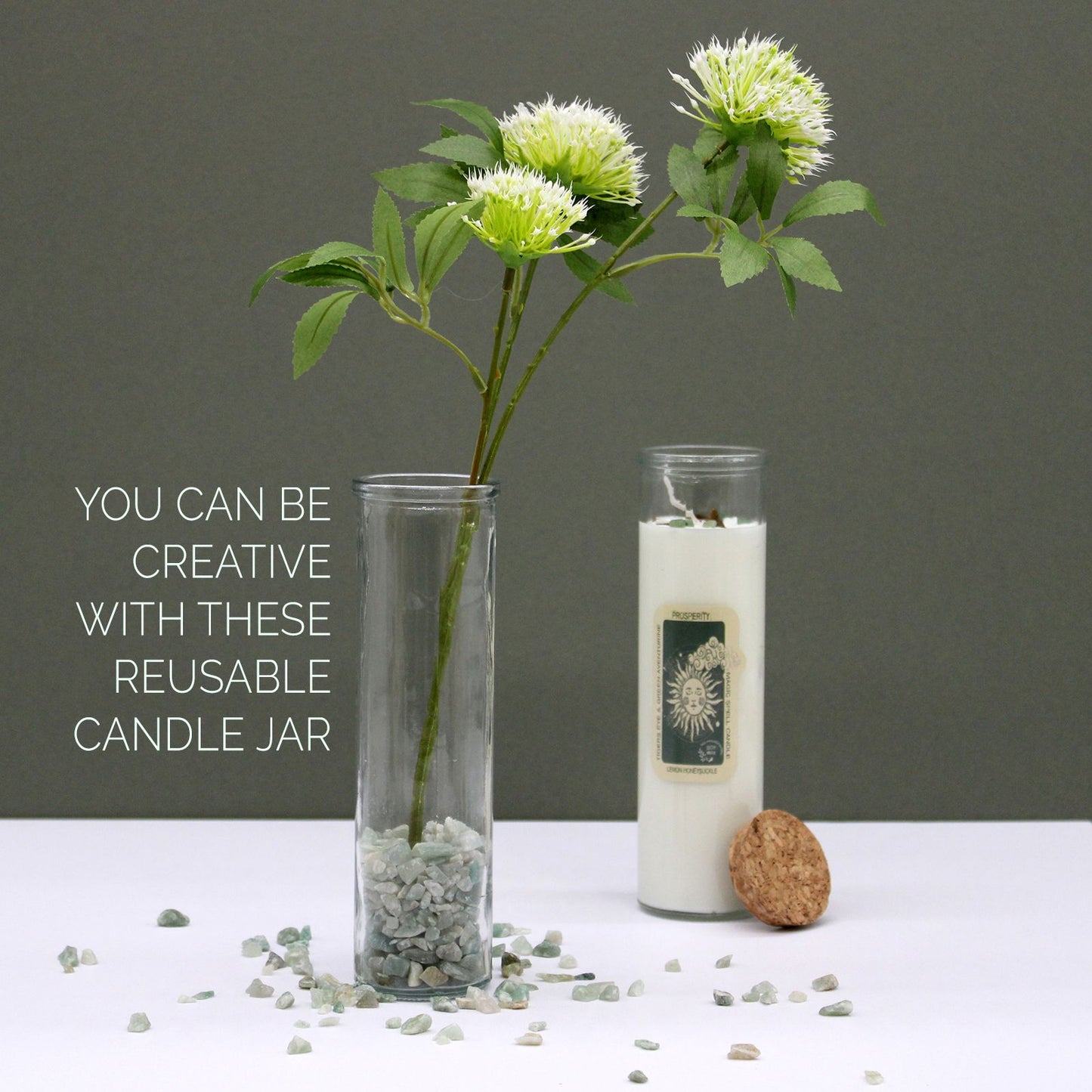 Ritualkerze mit Edelsteinen und Blumen in einem Glasgefäß.