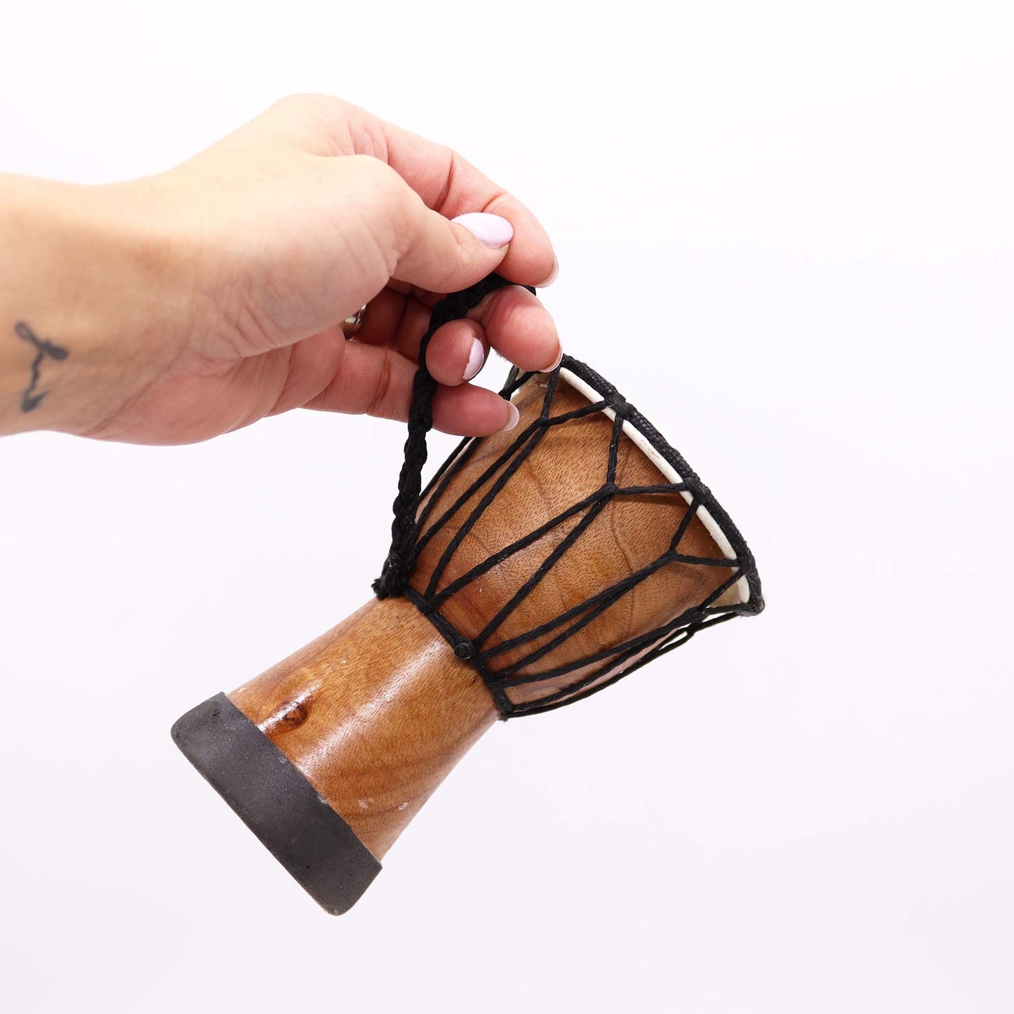 Handmade wooden djembe drum with black rope detailing.