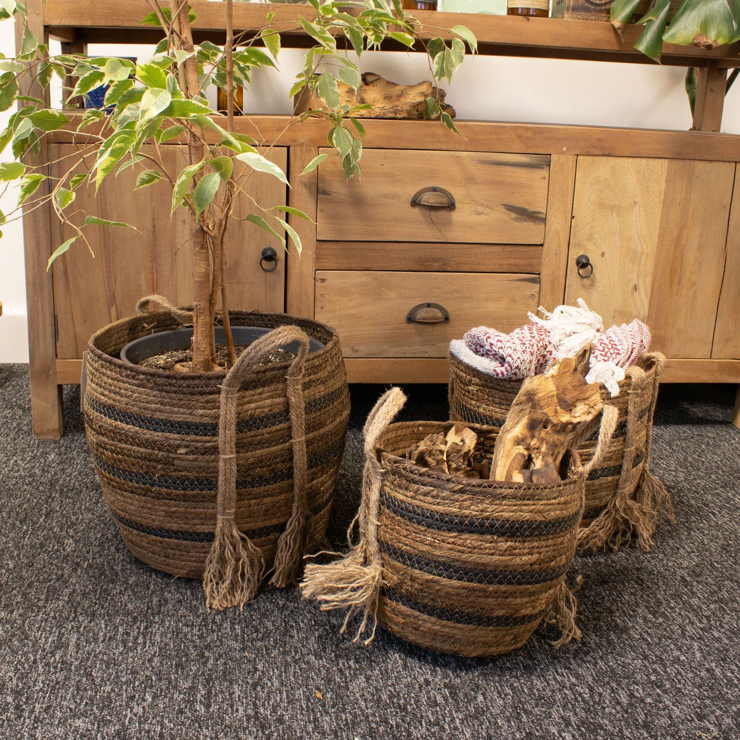 Set of 3 natural brown banana leaf and seagrass baskets with striped detailing and rope handles.