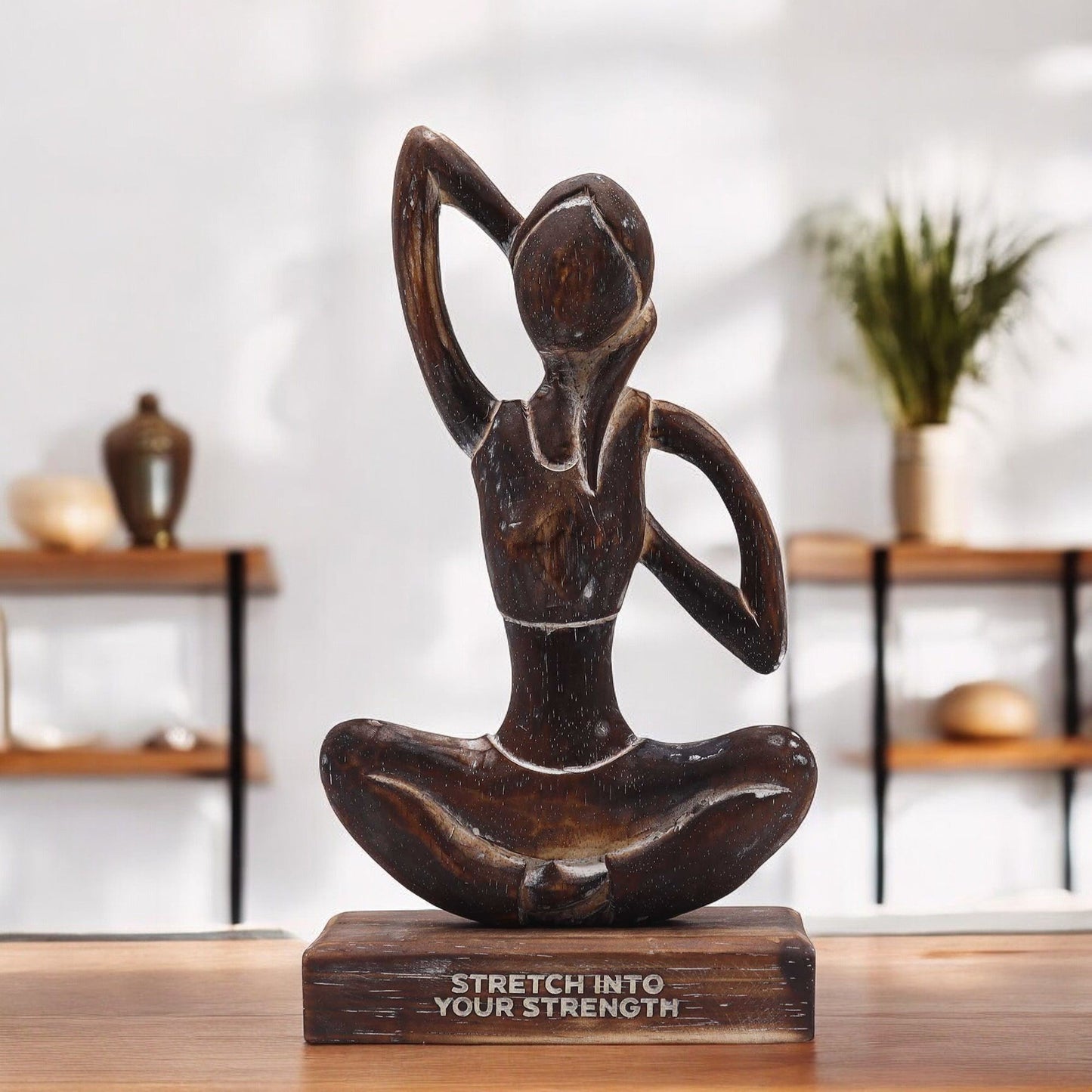 Yoga-Holzfigur mit der Aufschrift "Stretch into Your Strength".
