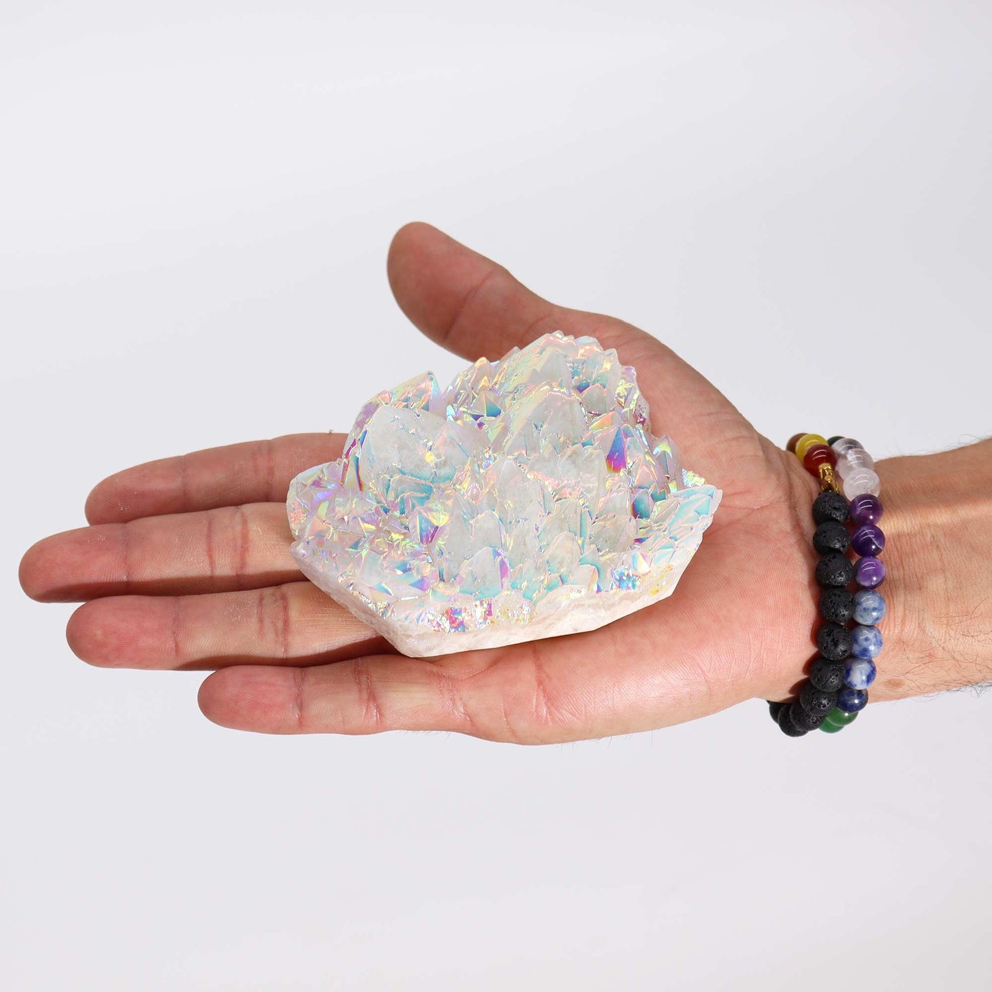 Großer Angel-Aura-Quarz-Cluster in einer Hand mit Armband