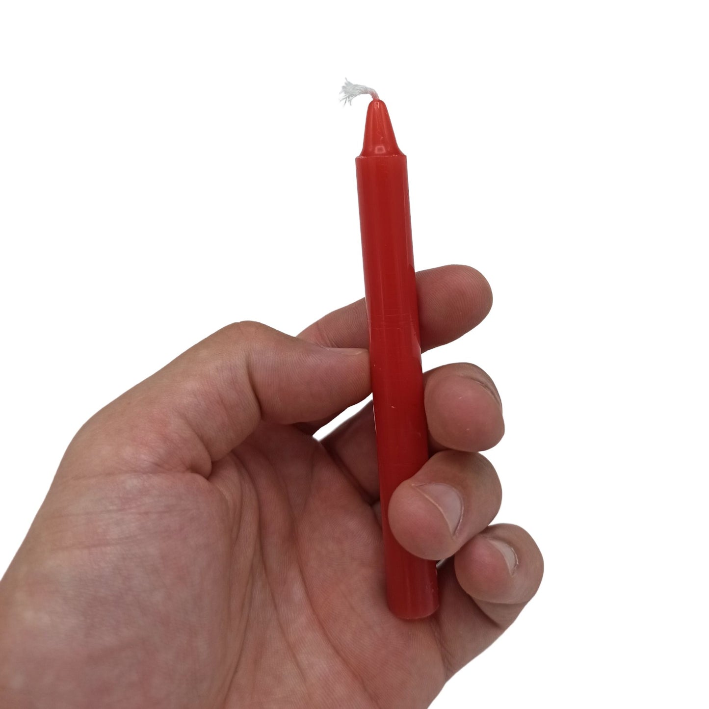 Eine rote Ritualkerze mit weißem Docht wird in einer Hand gehalten.