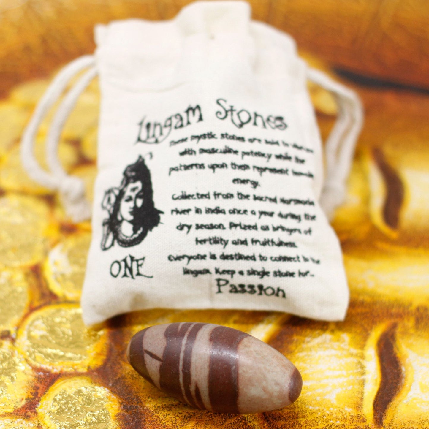 Ein Shiva Lingam Stein mit braunen Streifen liegt neben einem Beutel mit Beschriftung.