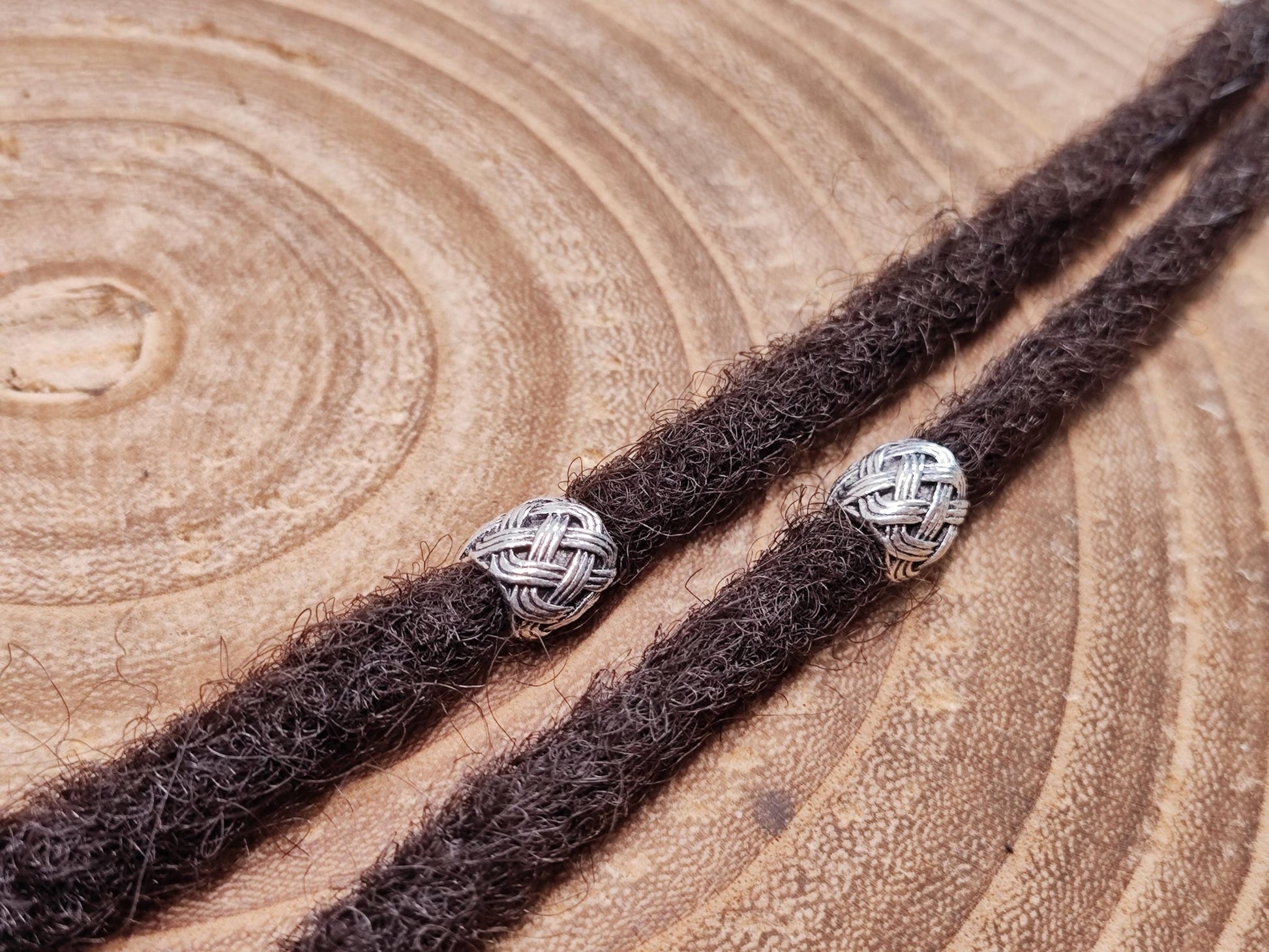 Set of 6 silver dreadlock beads with woven pattern.