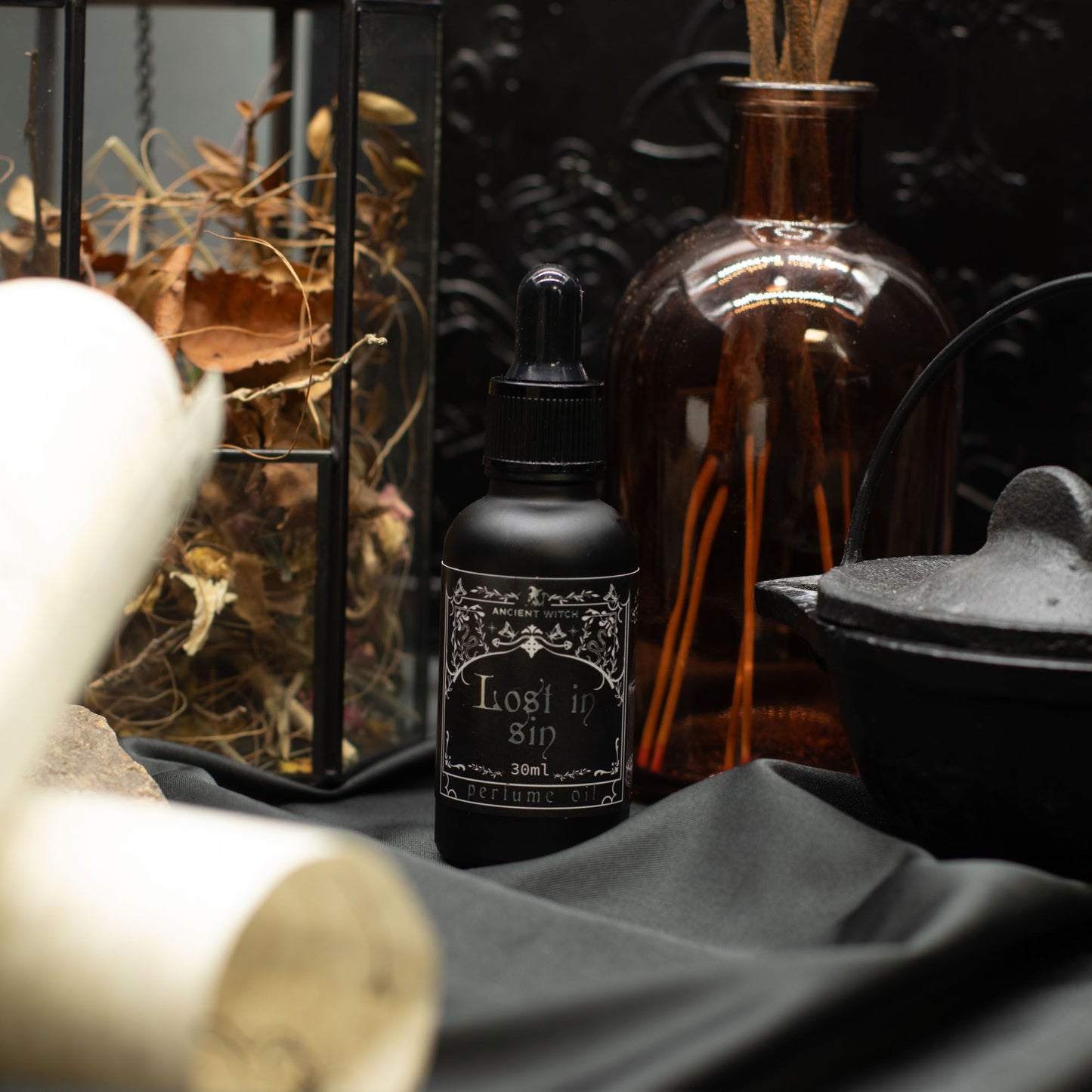 Black bottle of "Lost in Sin" perfume oil with a dropper top.