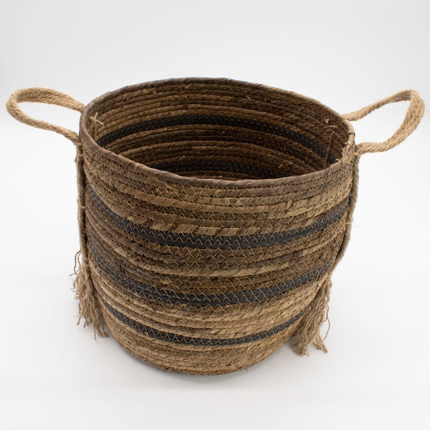 A round, woven basket made of natural brown banana leaf and seagrass with black stripes and rope handles.