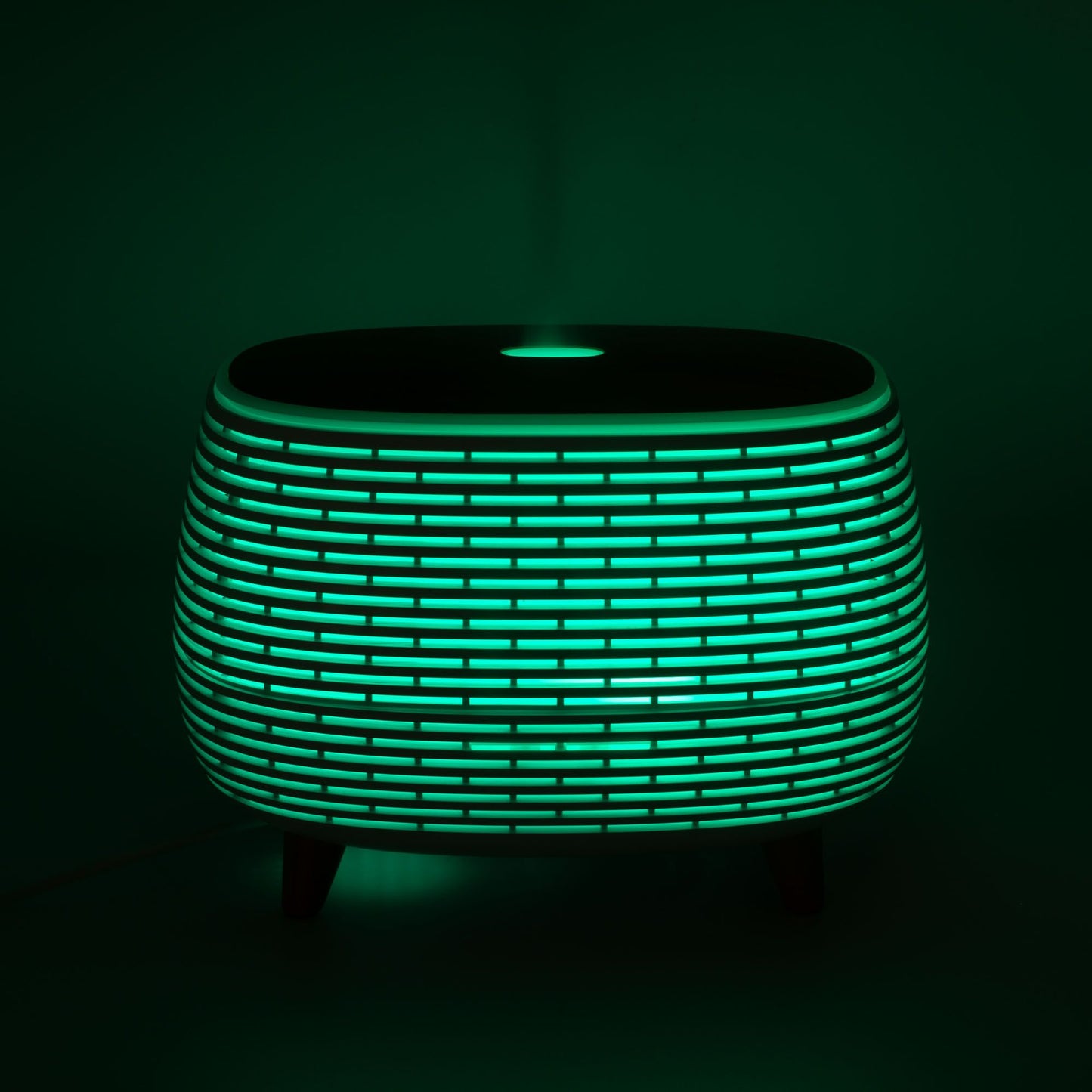 Futuristic ribbed aromatherapy diffuser with green light and wood-effect top.