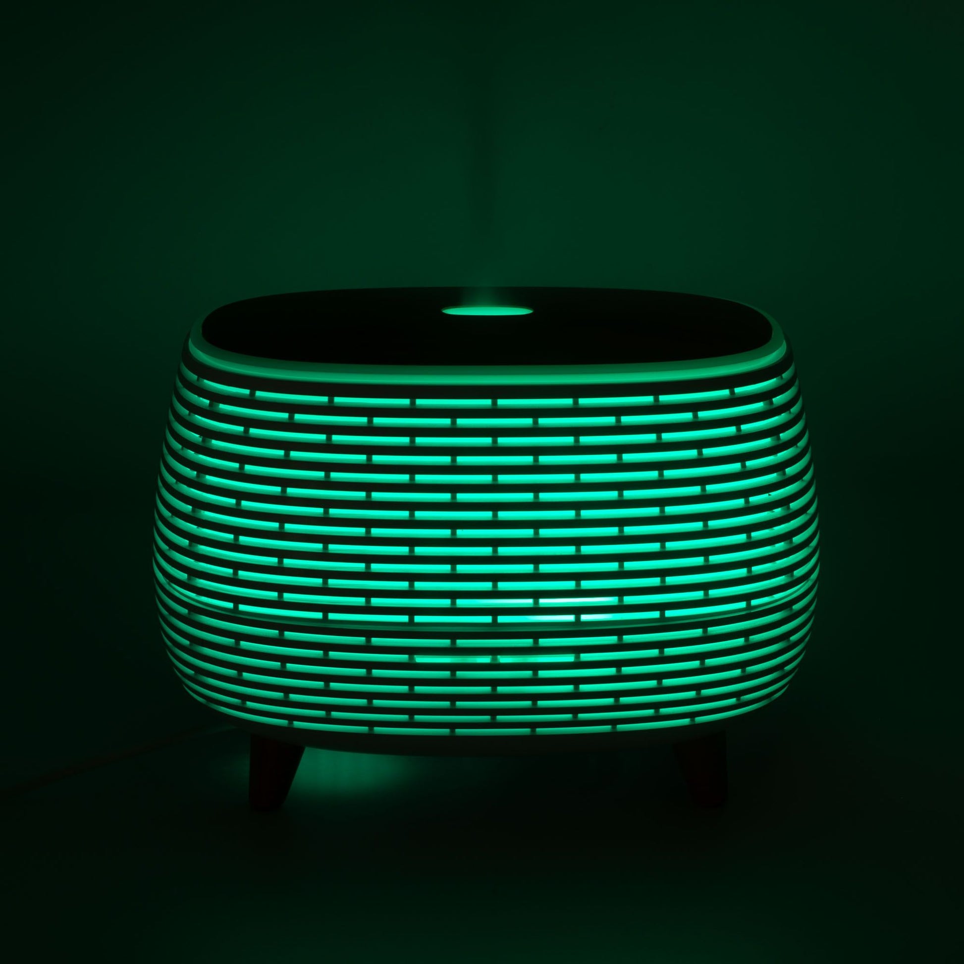 Futuristic ribbed aromatherapy diffuser with green light and wood-effect top.
