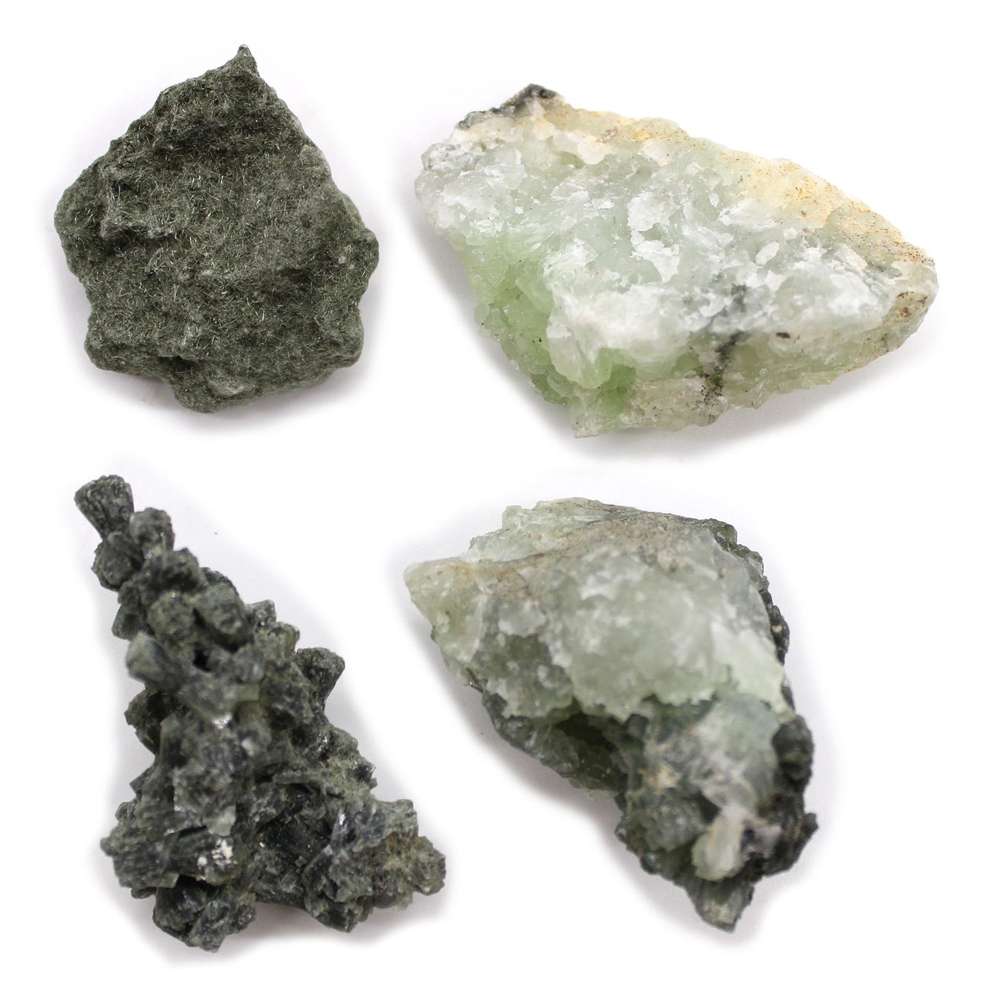 Vier rohe, grüne und hellgrüne Mineralien auf weißem Hintergrund.