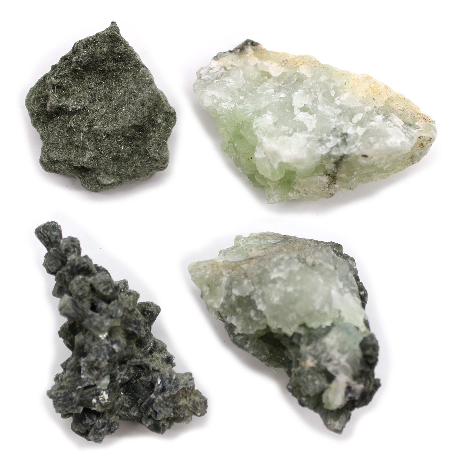 Vier rohe, grüne und hellgrüne Mineralien auf weißem Hintergrund.