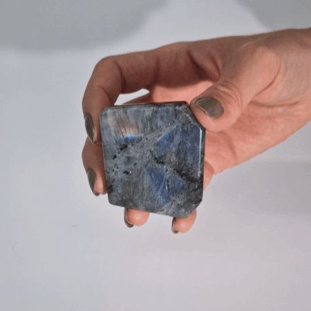 Ein großer, grauer Labradorit-Trommelstein mit blau-grüner Irisierung.