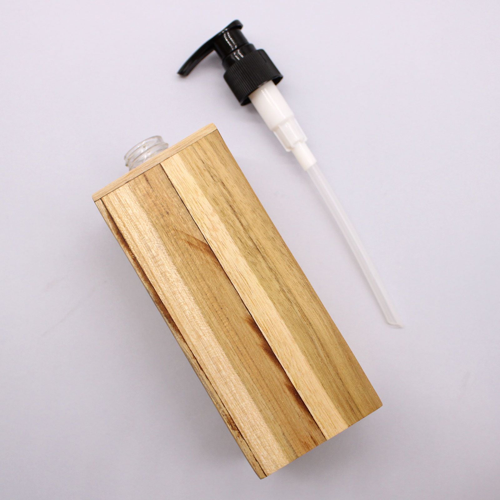 Square natural teakwood soap dispenser with a black pump dispenser.