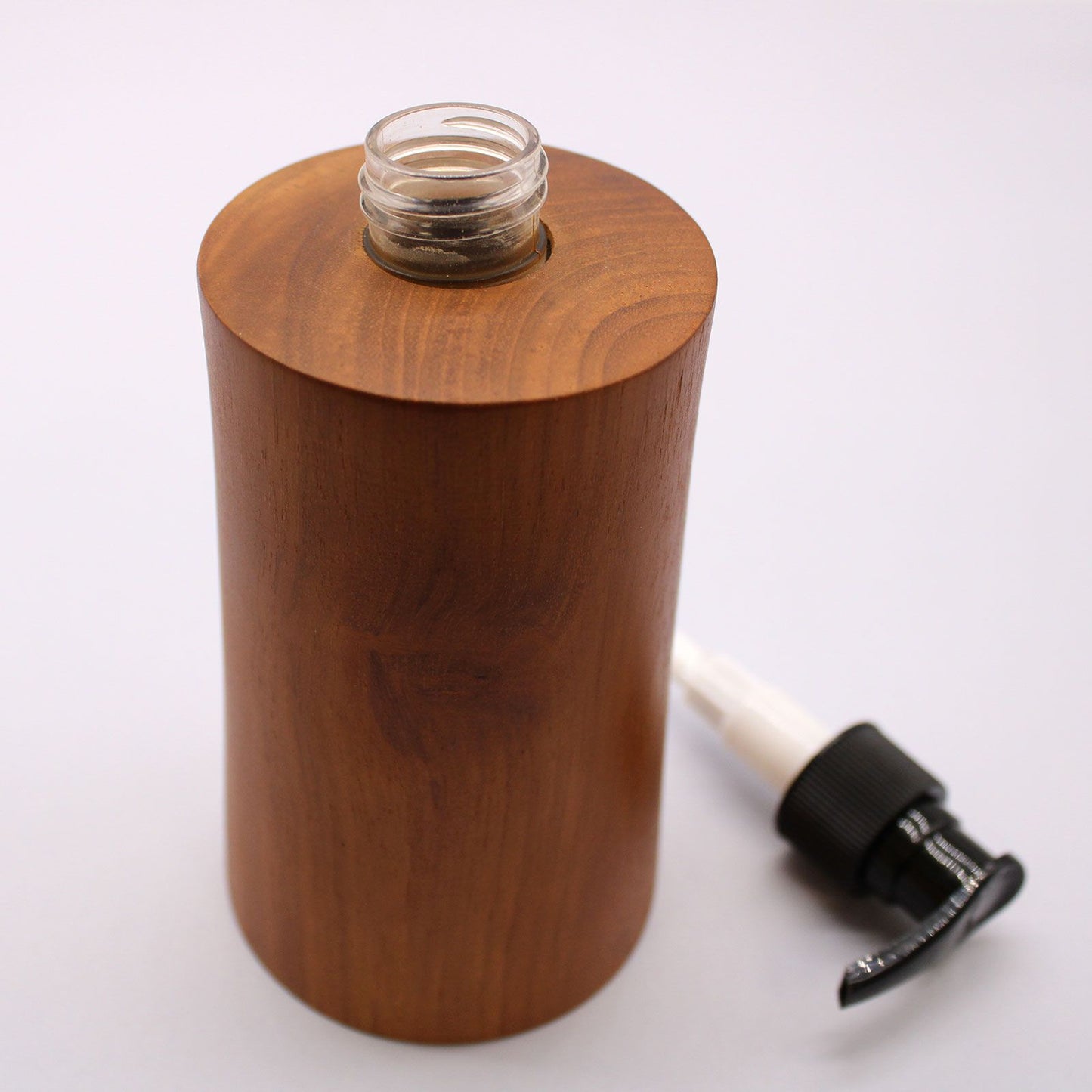Natural teakwood soap dispenser with a glass opening and a black pump dispenser.