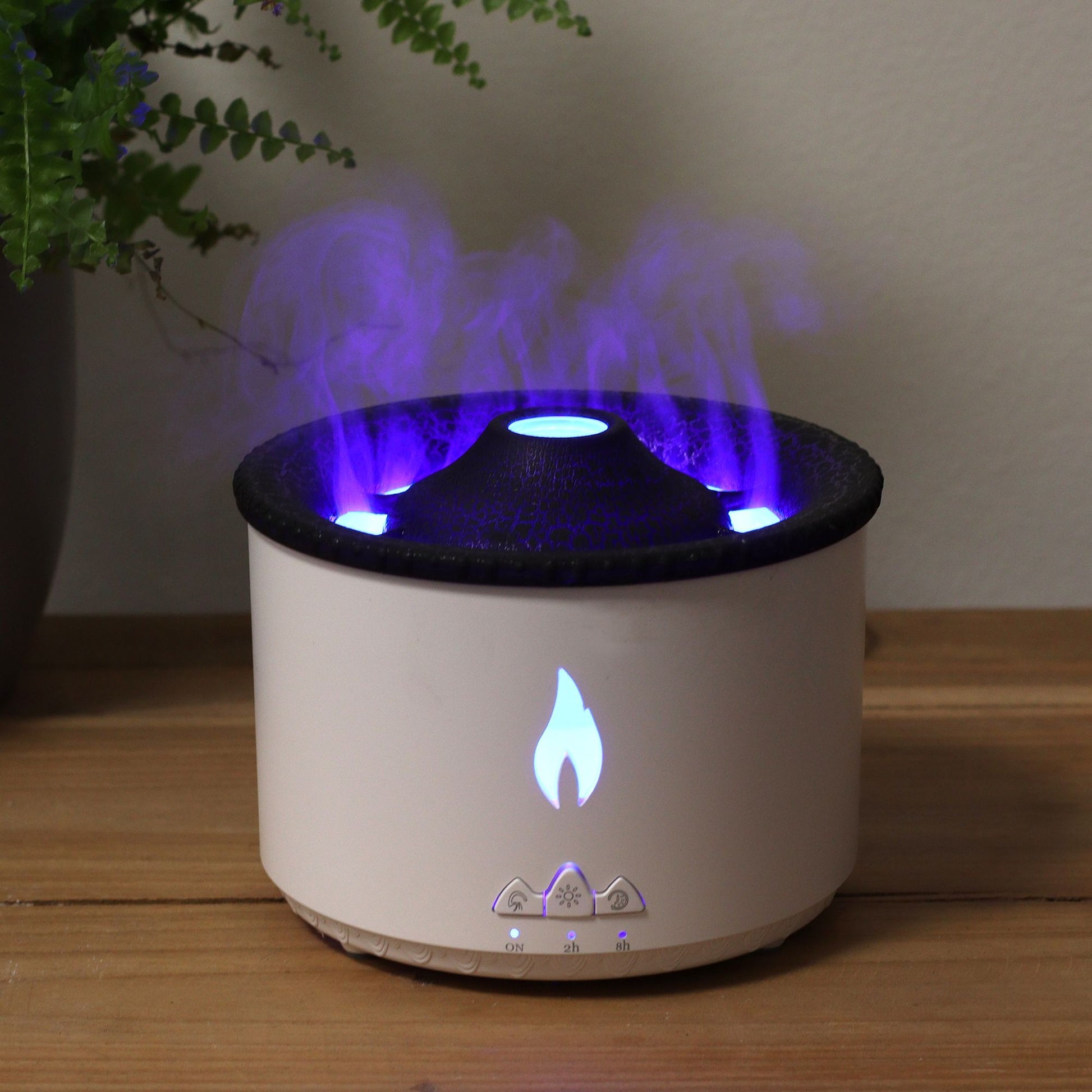 A white aroma diffuser with a volcano effect and blue flame light.