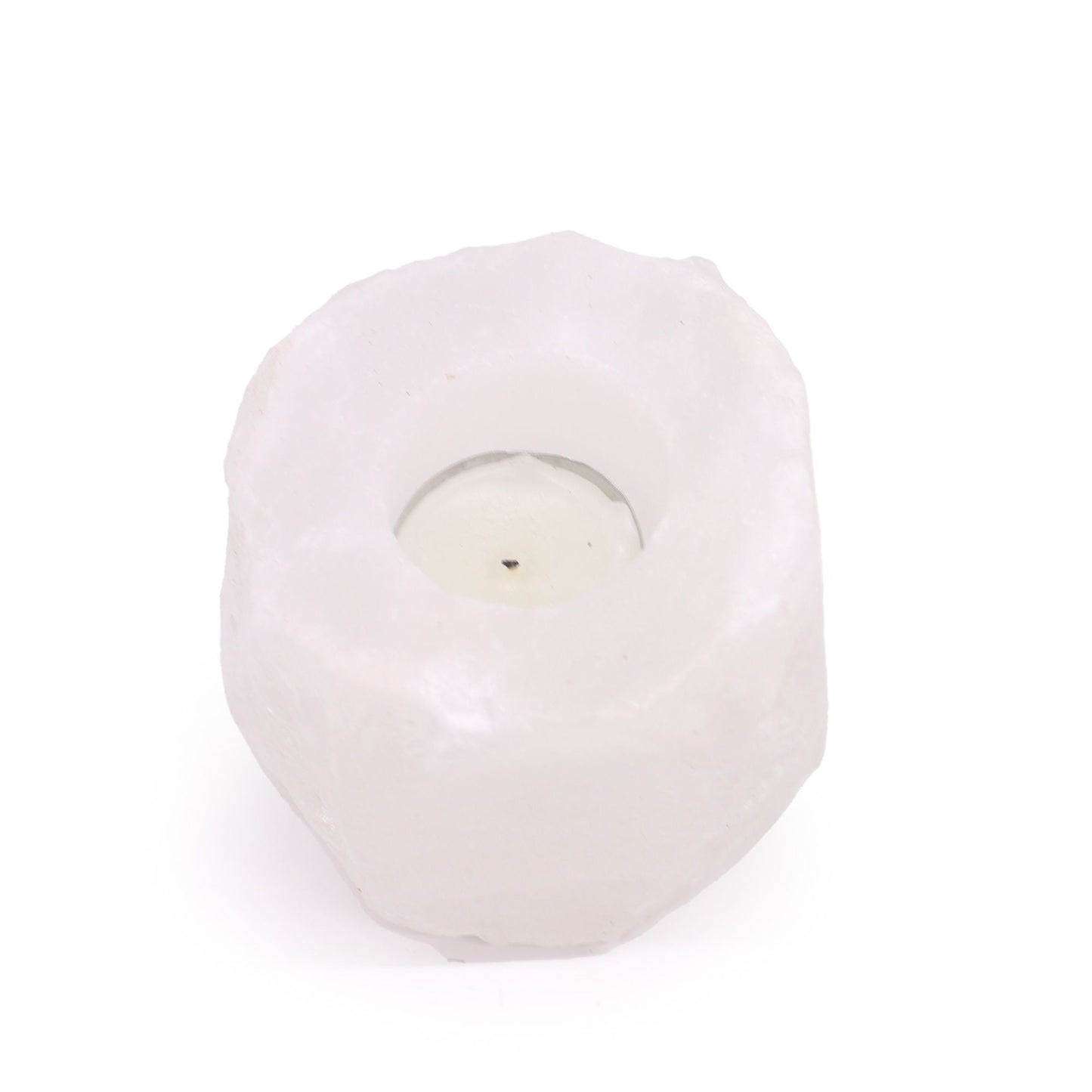 A white Himalayan salt candle holder with a tea light inside.