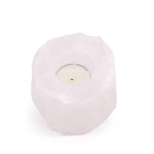 A white Himalayan salt candle holder with a tea light inside.