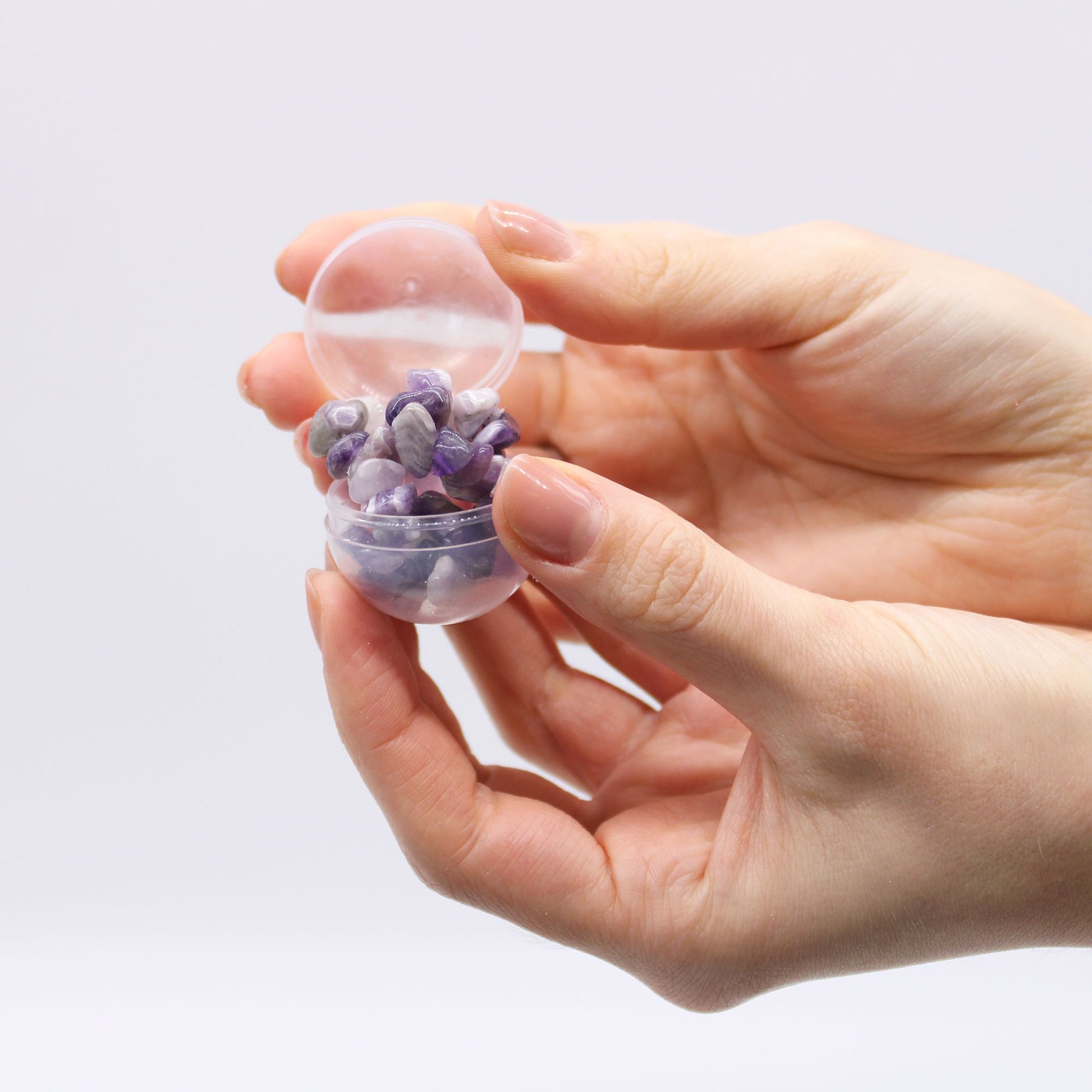 Badebombe mit Amethyst-Armband in einer durchsichtigen Kugel.