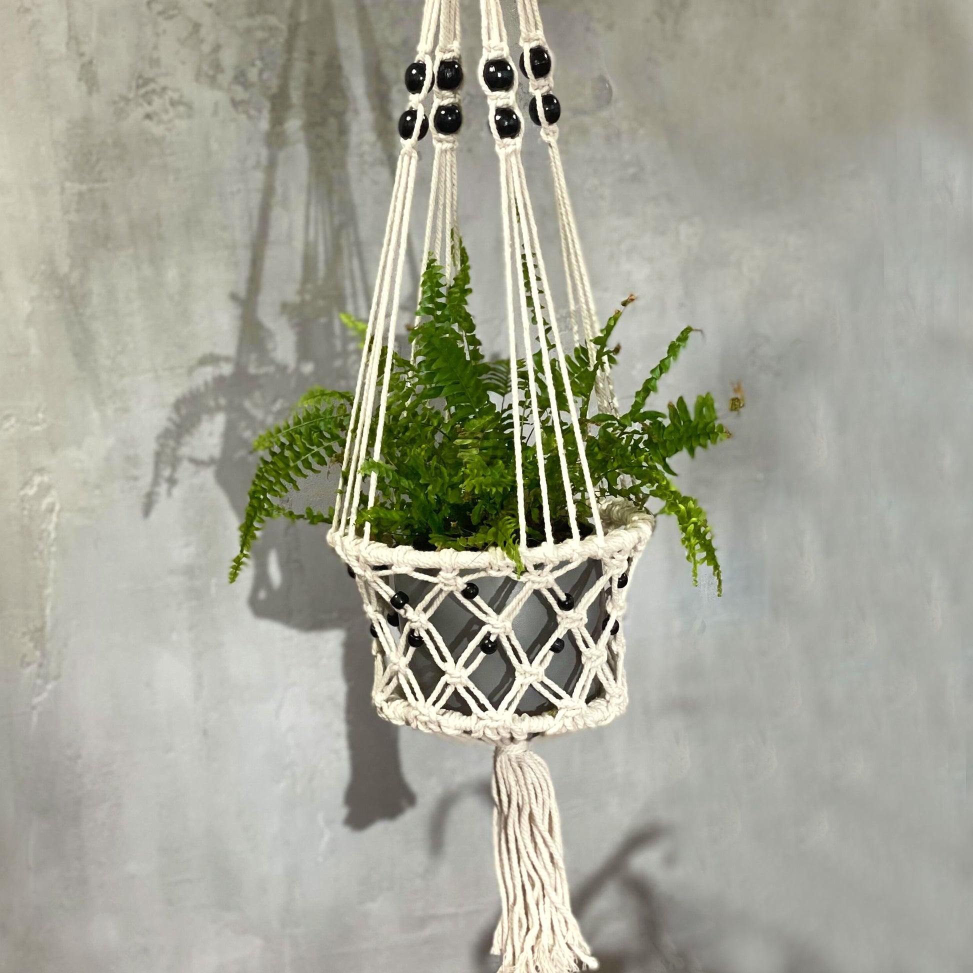 Großer Makramee Blumentopfhalter mit schwarzen Perlen und Quaste.