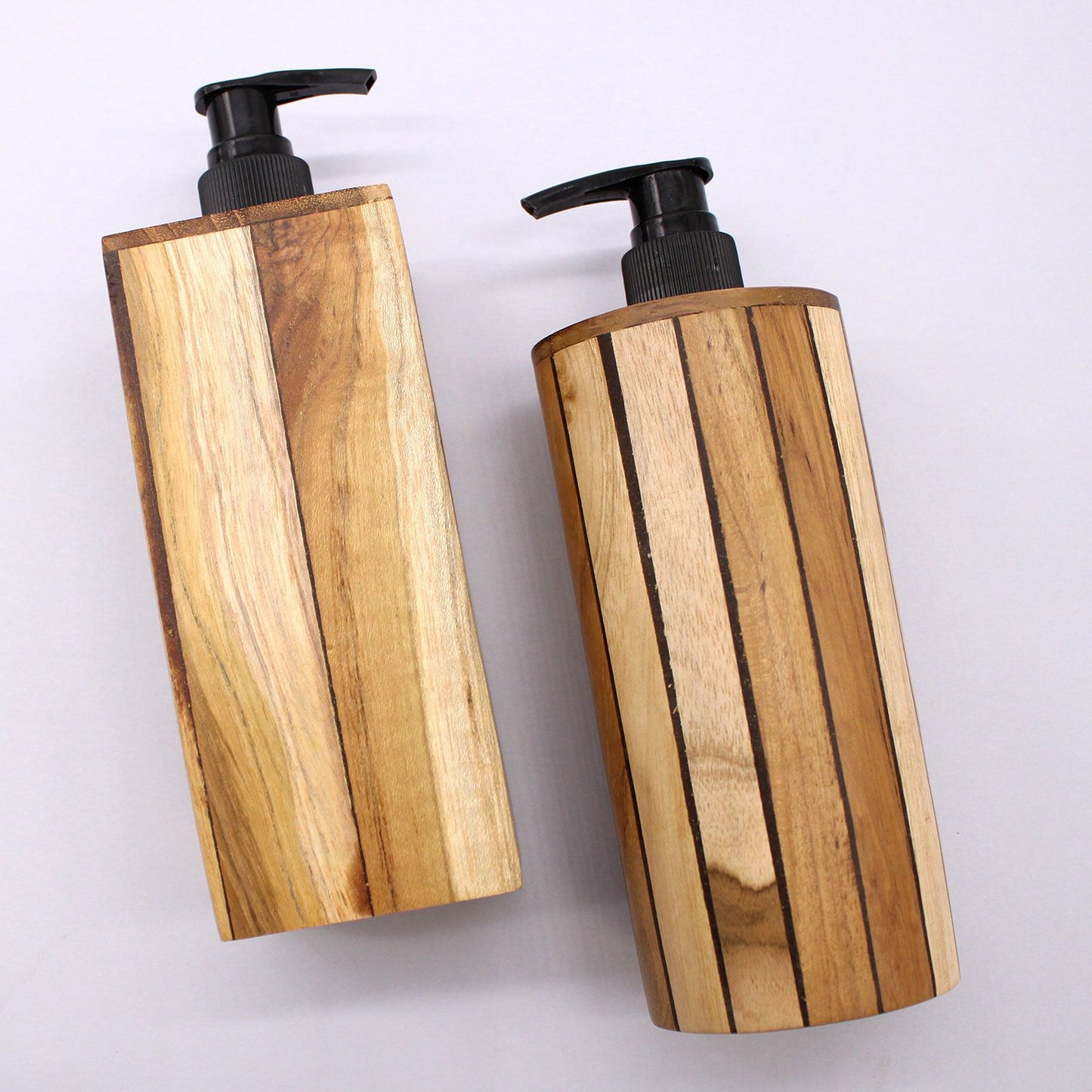 Two natural teakwood soap dispensers with black pumps on a white background.