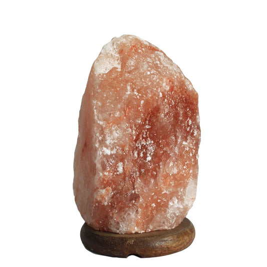 A natural pink Himalayan salt lamp on a wooden base.