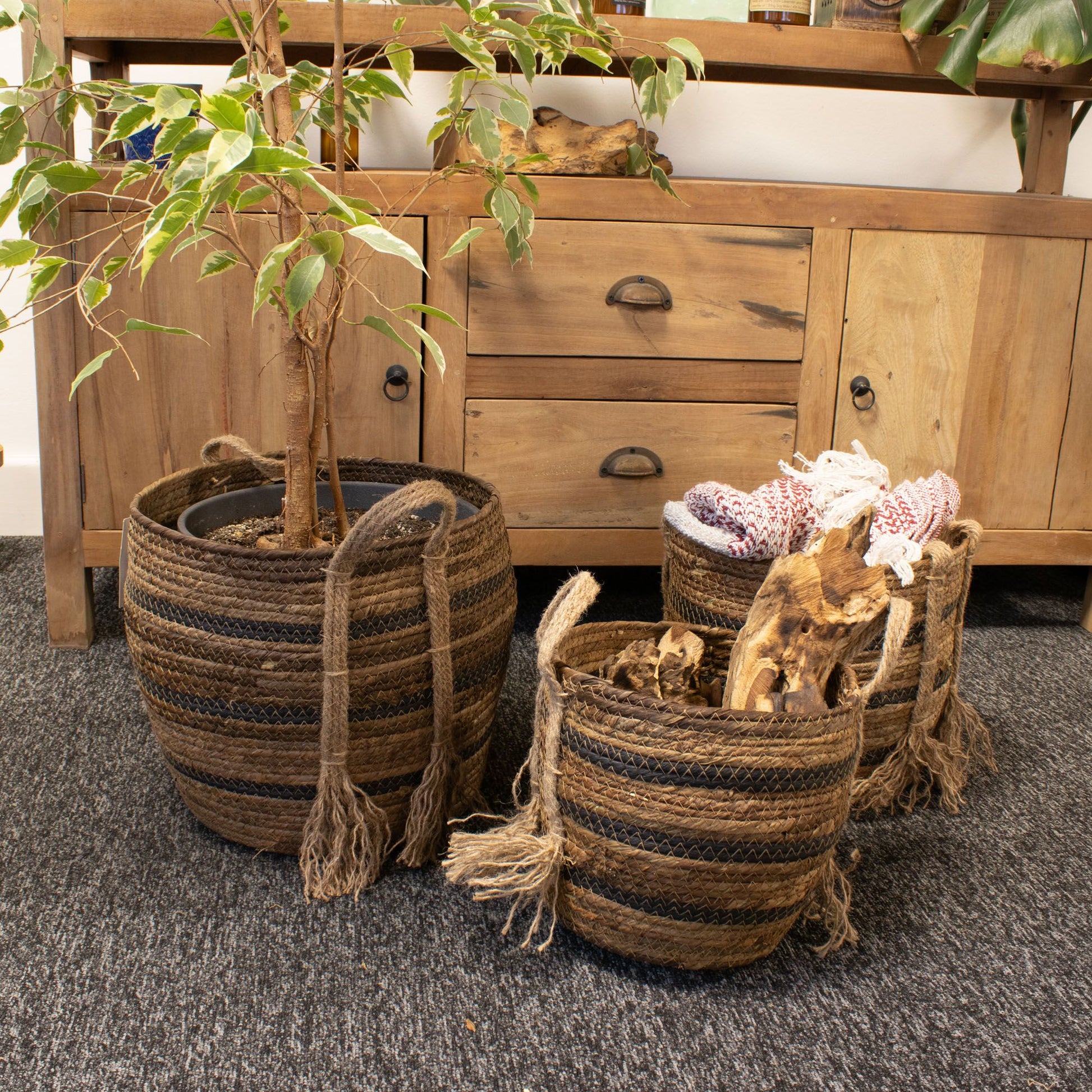 Set of 3 natural brown banana leaf and seagrass baskets with striped detailing and rope handles.