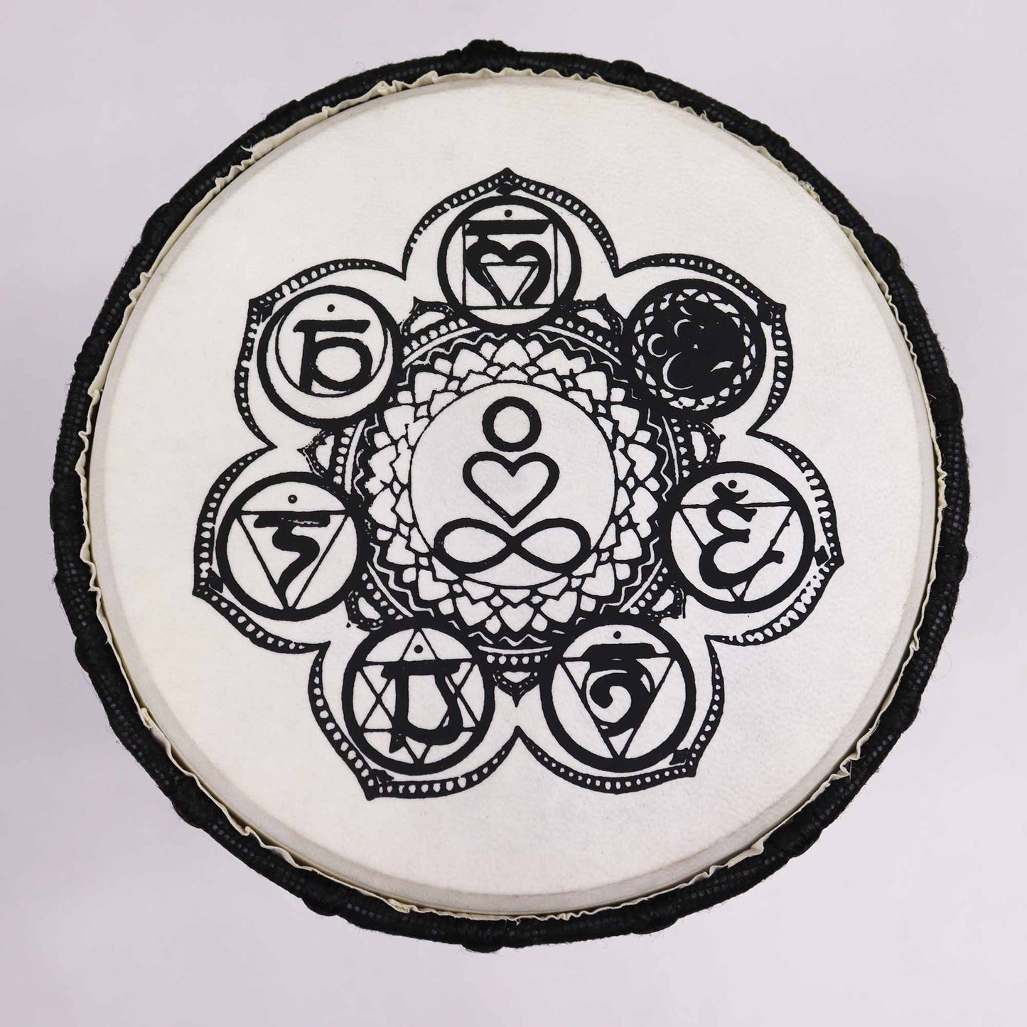 Handmade djembe drum with a black and white chakra design.