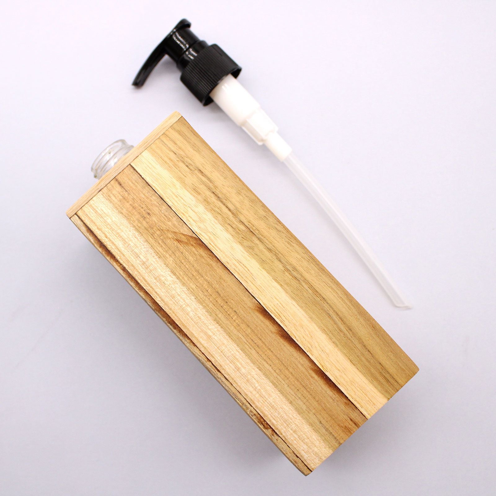 Square natural teakwood soap dispenser with a black pump dispenser.