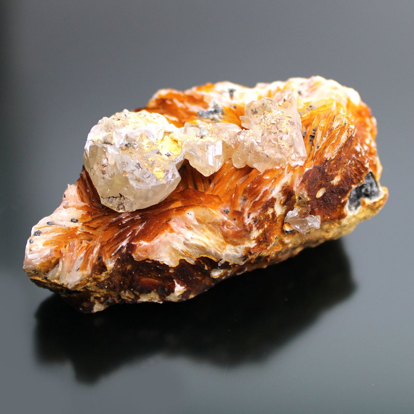 Barit-Sericit Rohstein mit klaren Kristallen und orange-braunen Fasern.