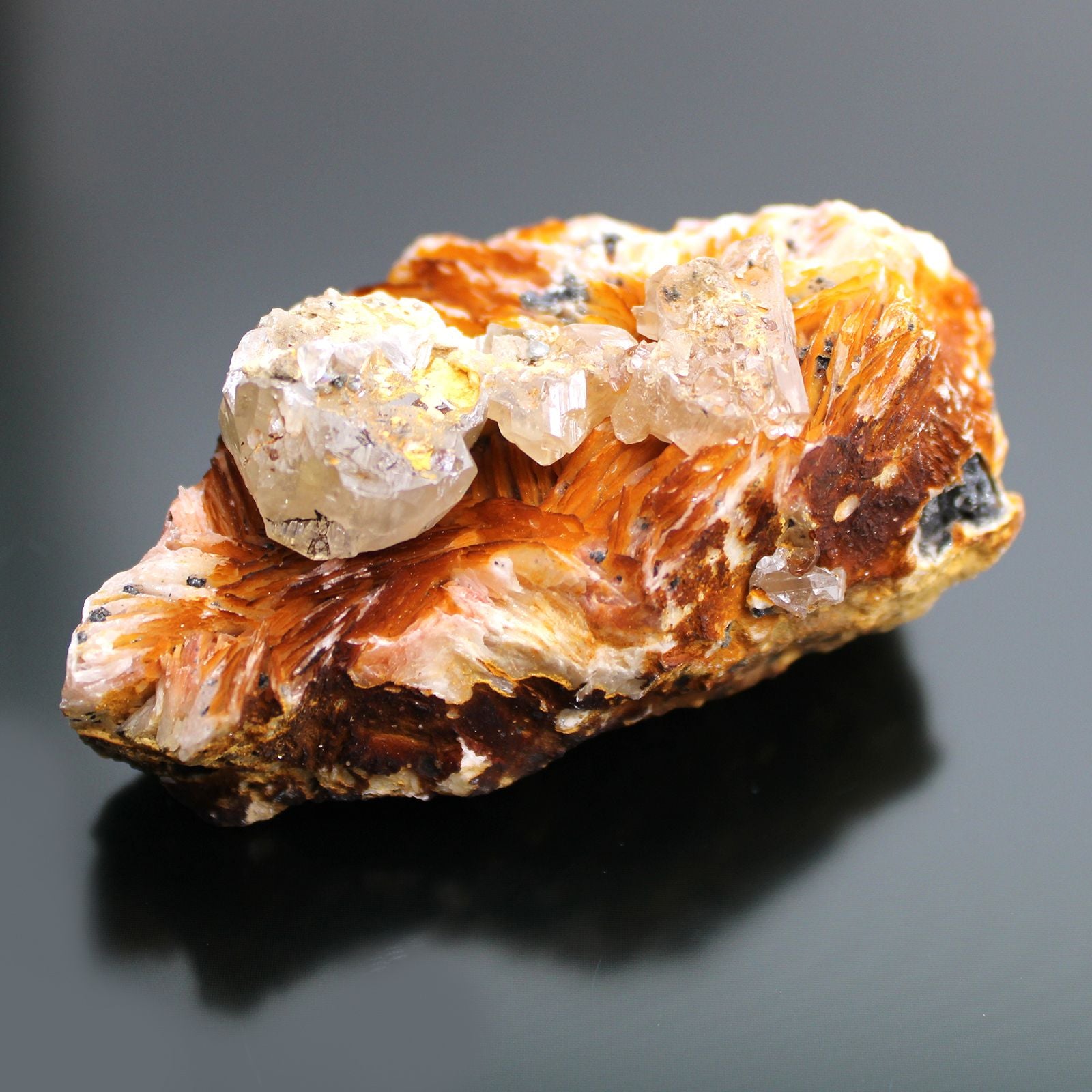 Barit-Sericit Rohstein mit klaren Kristallen und orange-braunen Fasern.