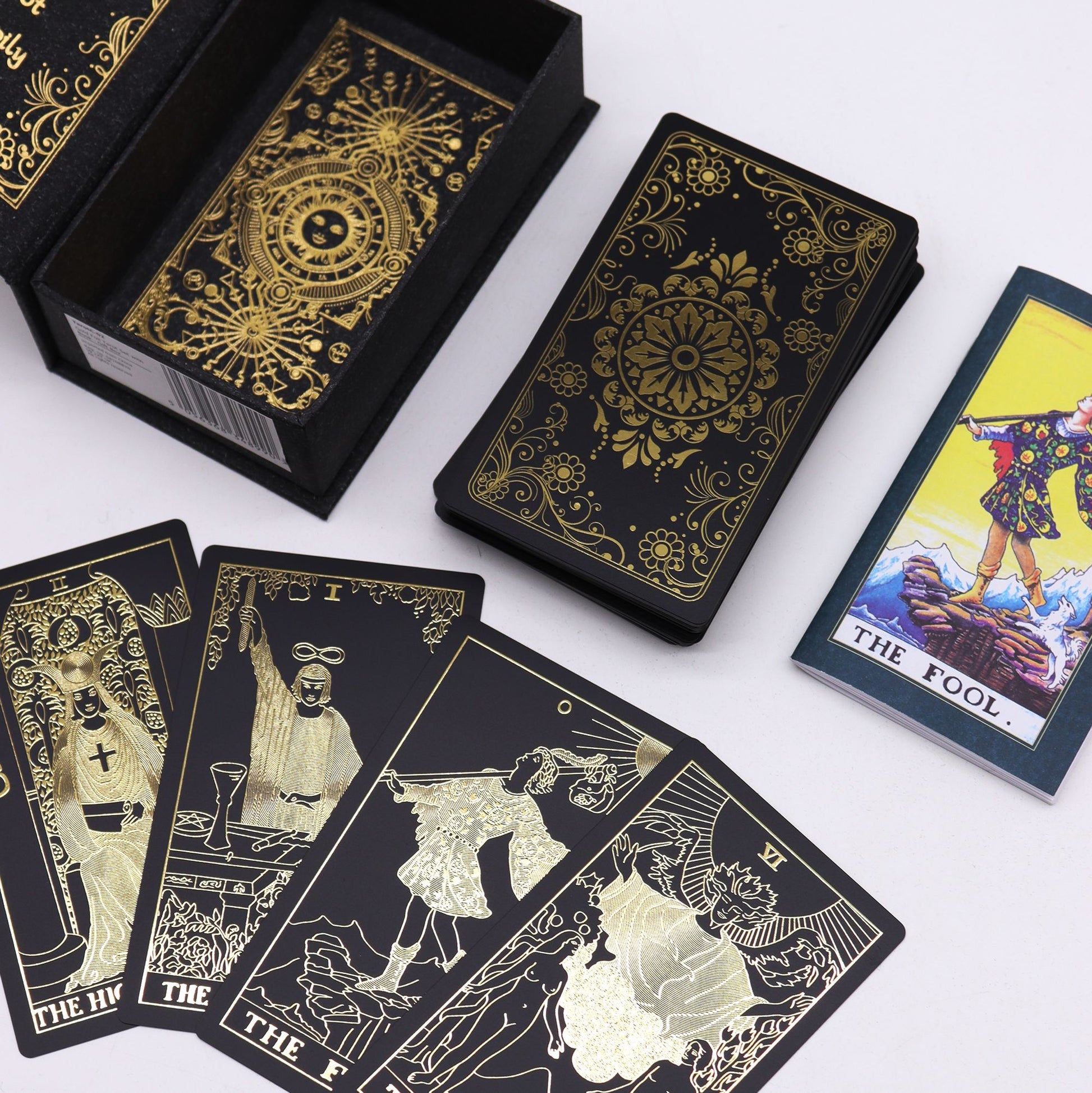 Ein Tarot-Geschenkset mit schwarzen Karten und goldener Folienprägung in einer schwarzen Box.