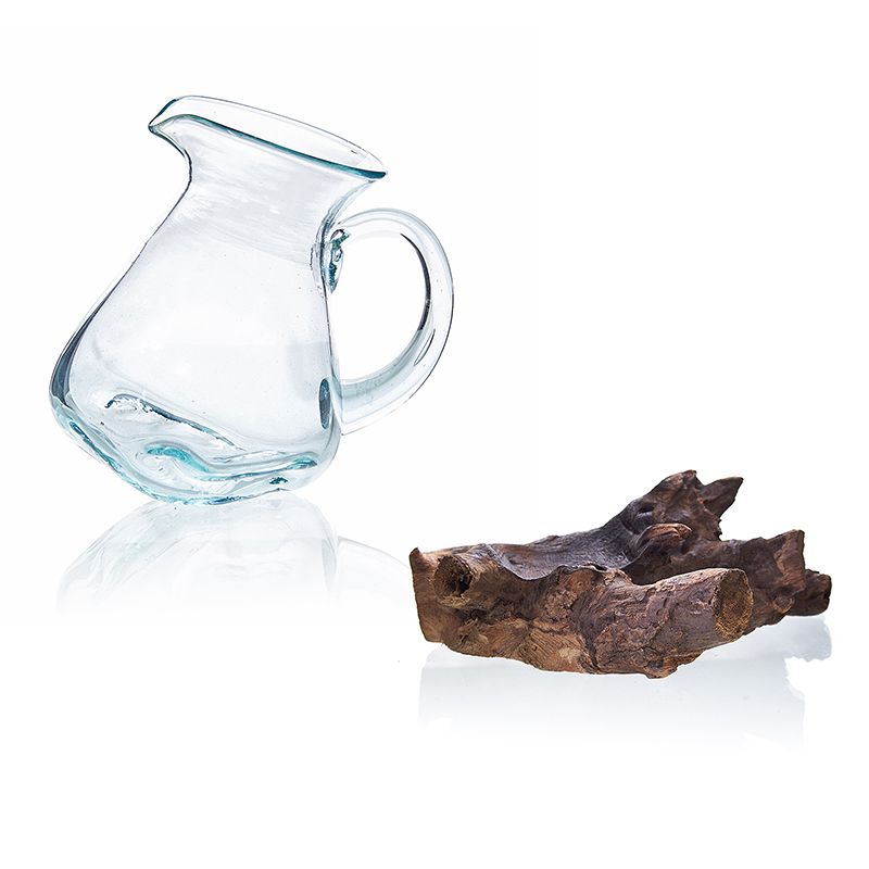 Handgefertigte Karaffe aus recyceltem Glas auf Wurzelholz.