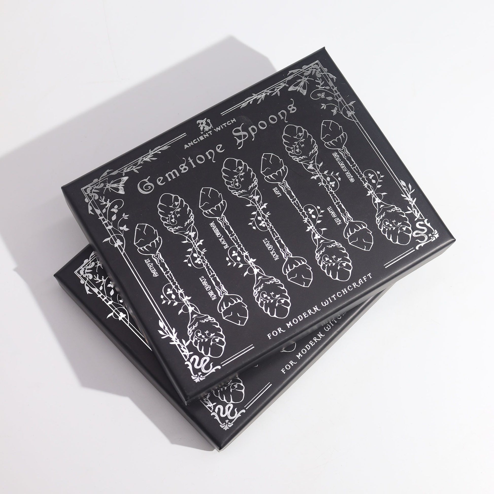 Set of 7 dark silver gemstone crystal witch spoons with intricate designs.