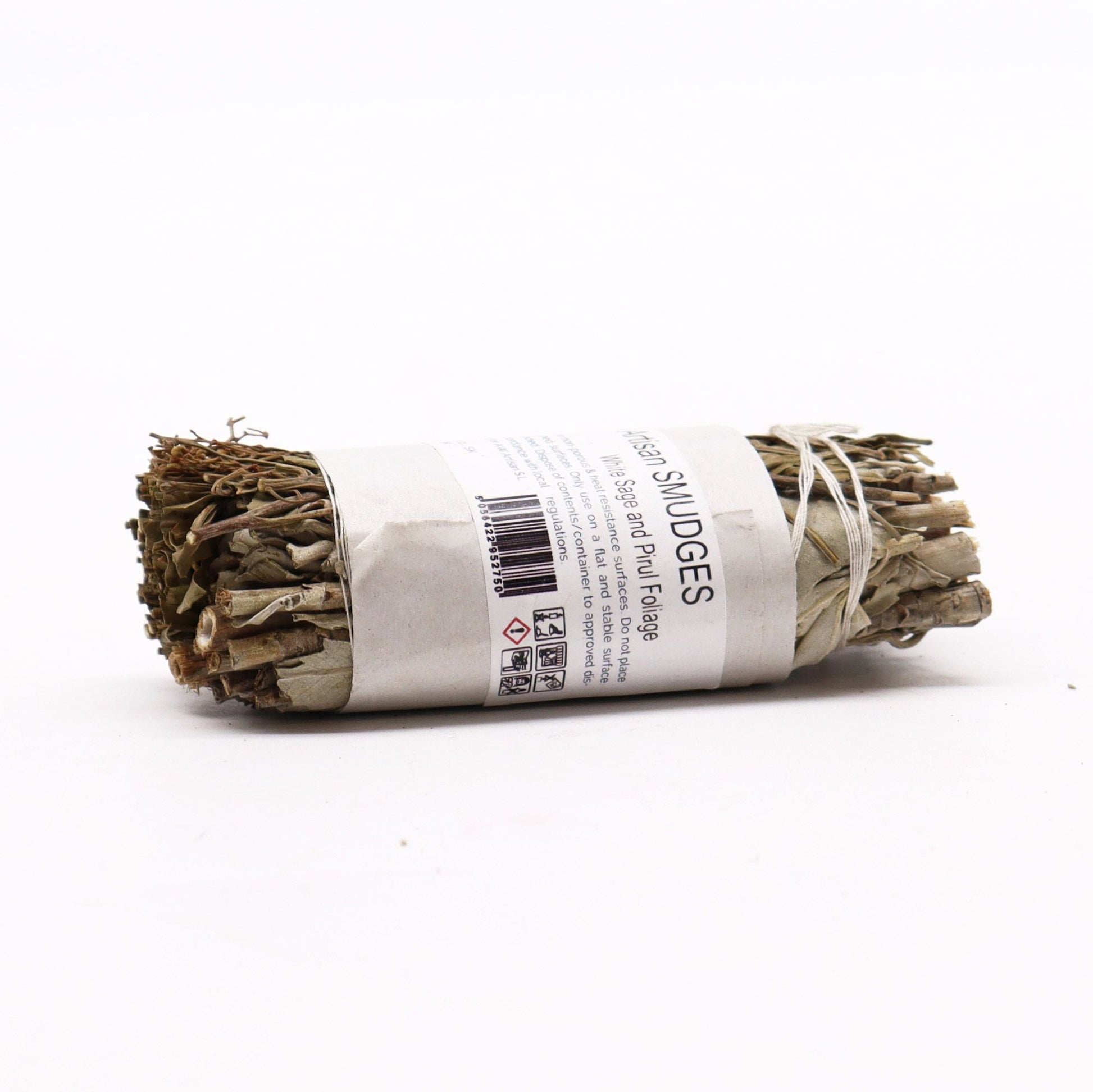 Smudge stick bundle of white sage and pirul foliage tied with string.