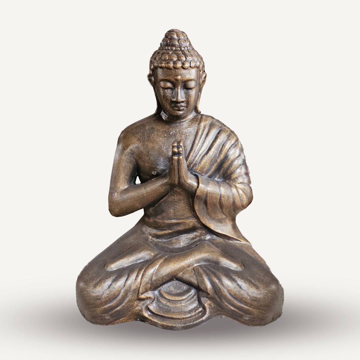 Bronzefarbene Buddha-Statue in meditativer Haltung.