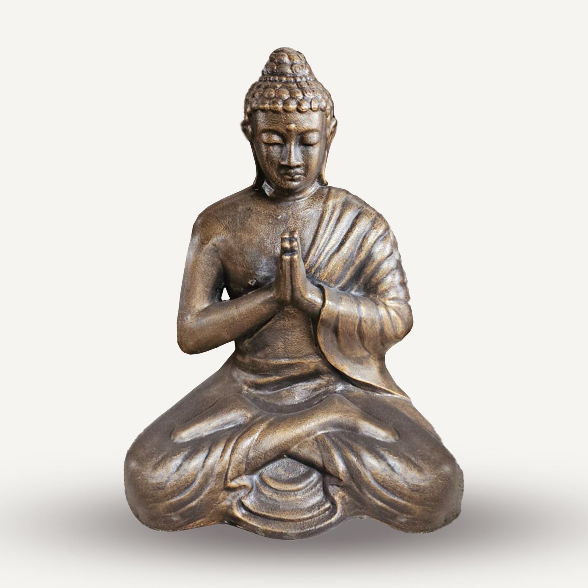 Bronzefarbene Buddha-Statue in meditativer Haltung.