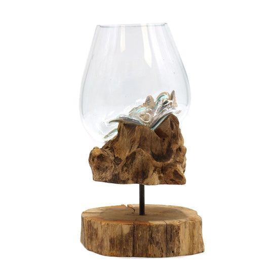Large clear glass bowl with molten glass accents resting on a carved wood base with a wood slice stand.