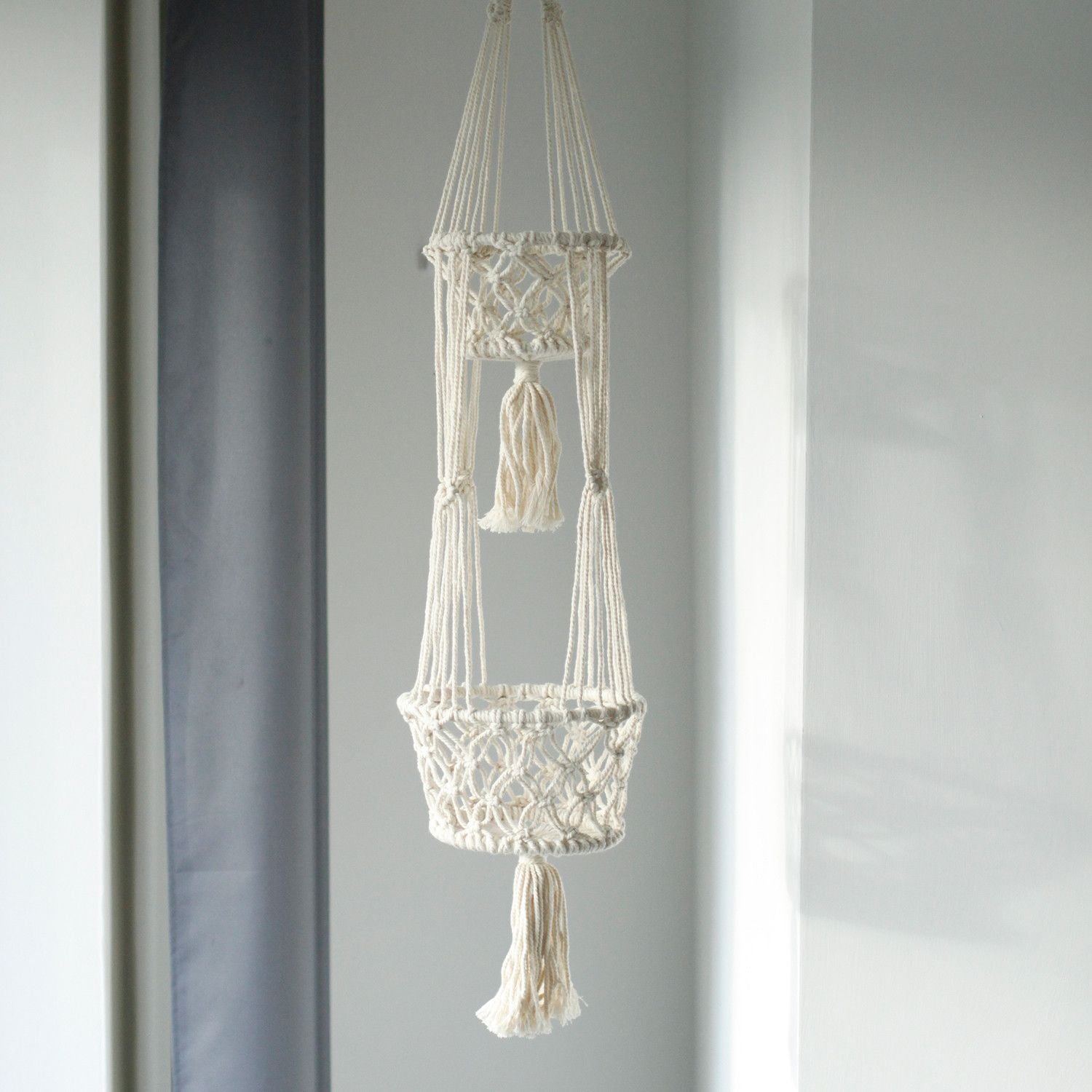 Doppelter Makramee-Blumentopfhalter aus Baumwolle mit Quasten.