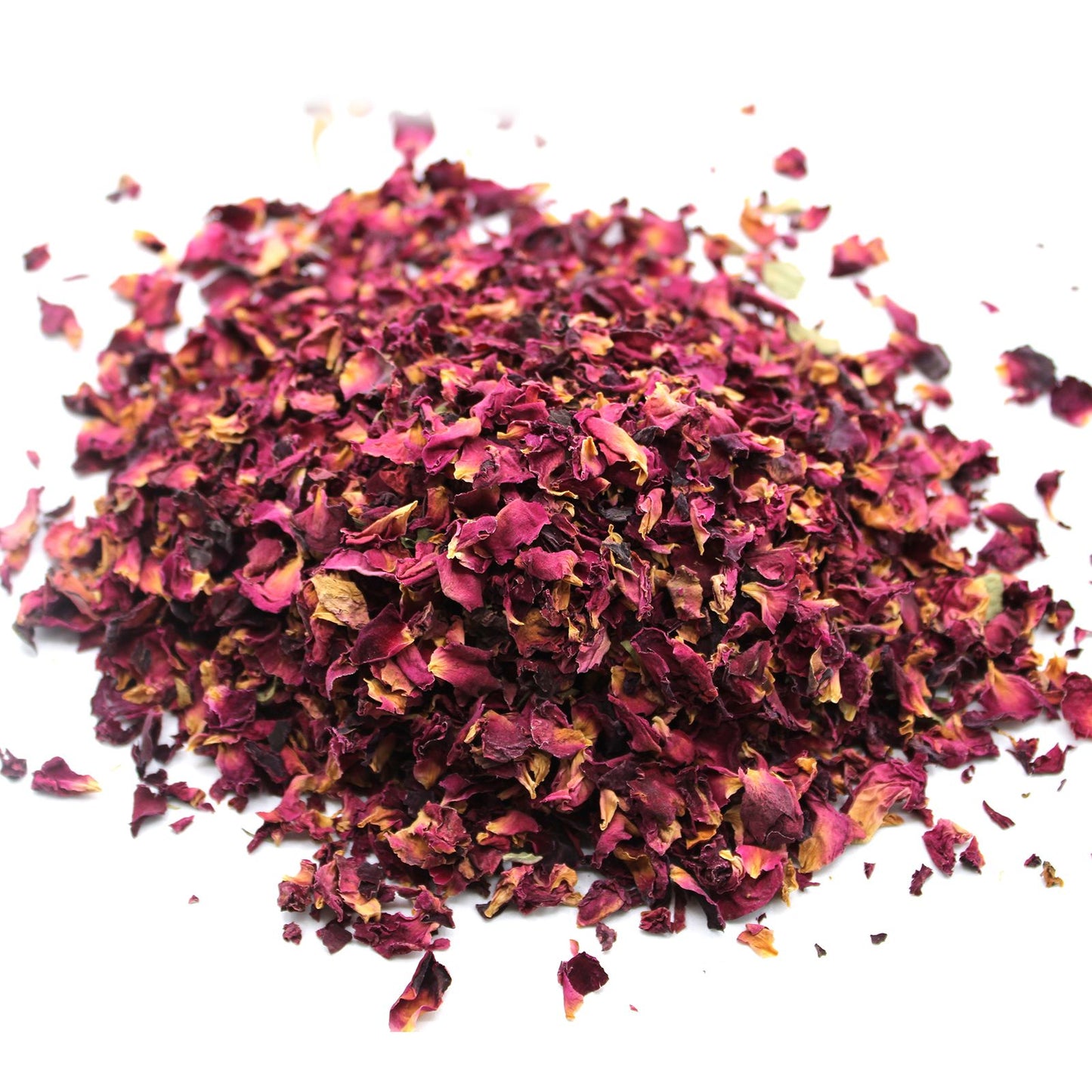 Dried red rose petals scattered on a white background.