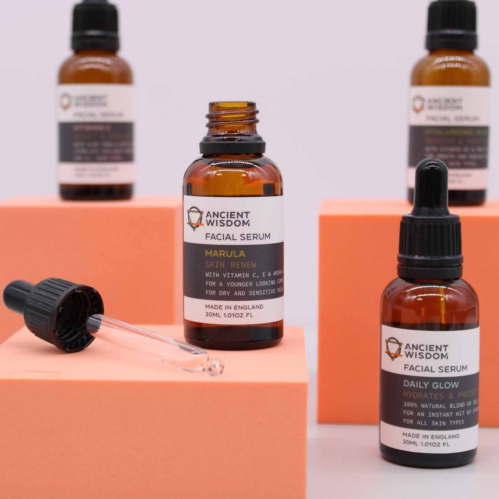 Amber glass facial serum bottles with droppers on orange blocks.