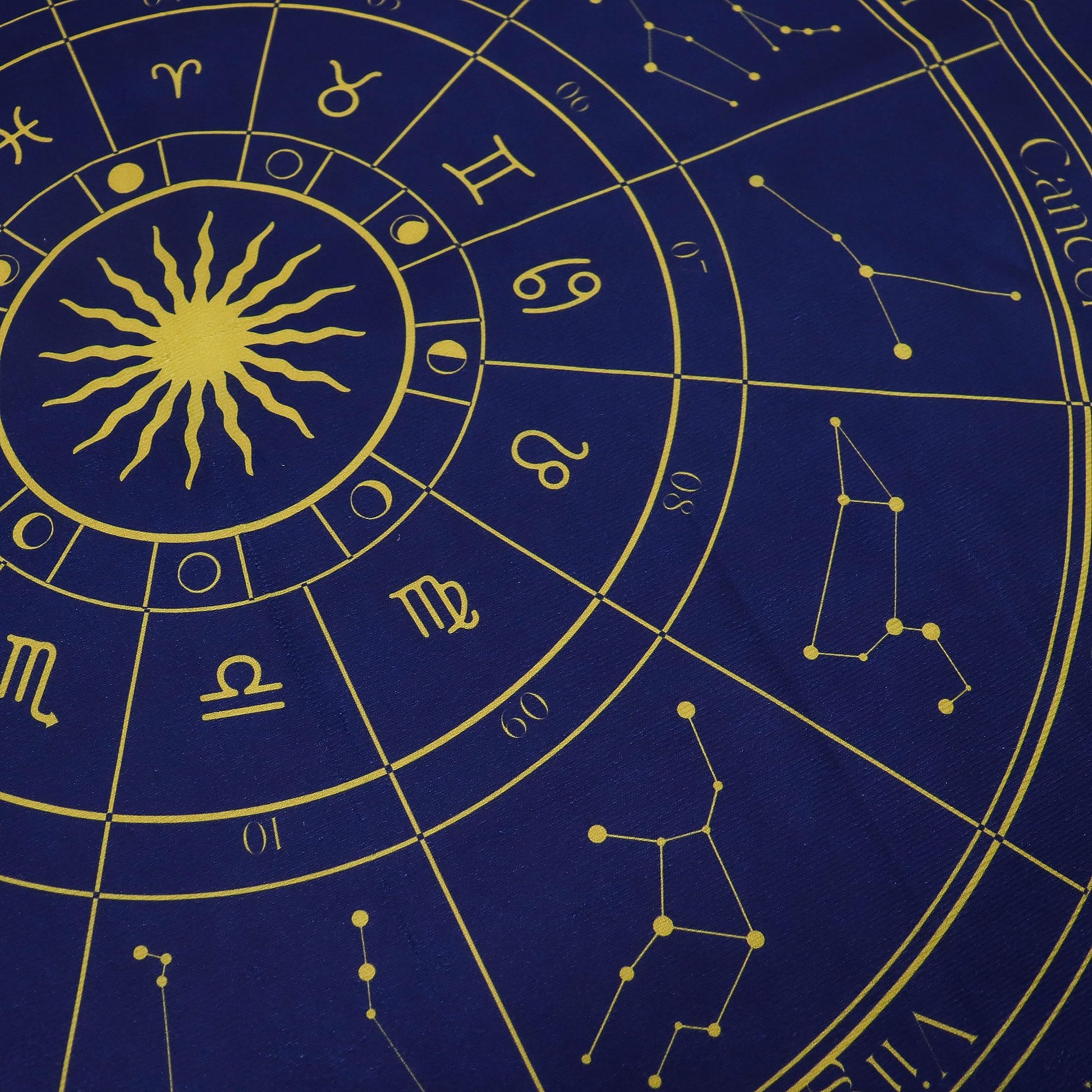 Zodiac tarot cloth with a detailed sun and astrological symbols on a blue background.