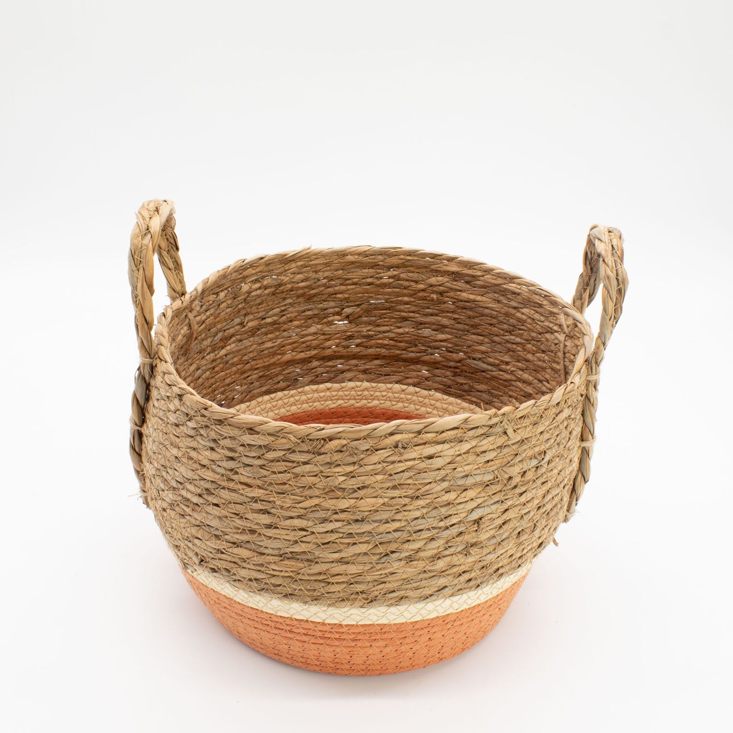 A round woven straw and seagrass basket with handles and an orange base.