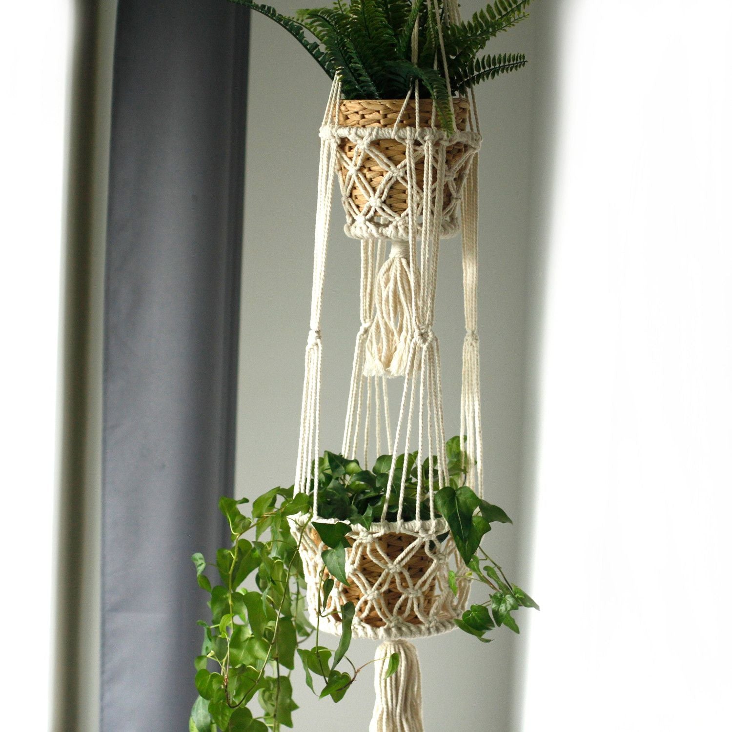 Doppelter Makramee-Blumentopfhalter mit zwei Pflanzenkörben.