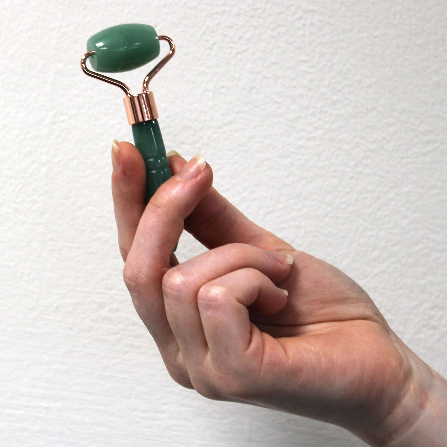 Mini Edelstein-Gesichtsroller aus Bergkristall mit roségoldfarbenem Metallrahmen.
