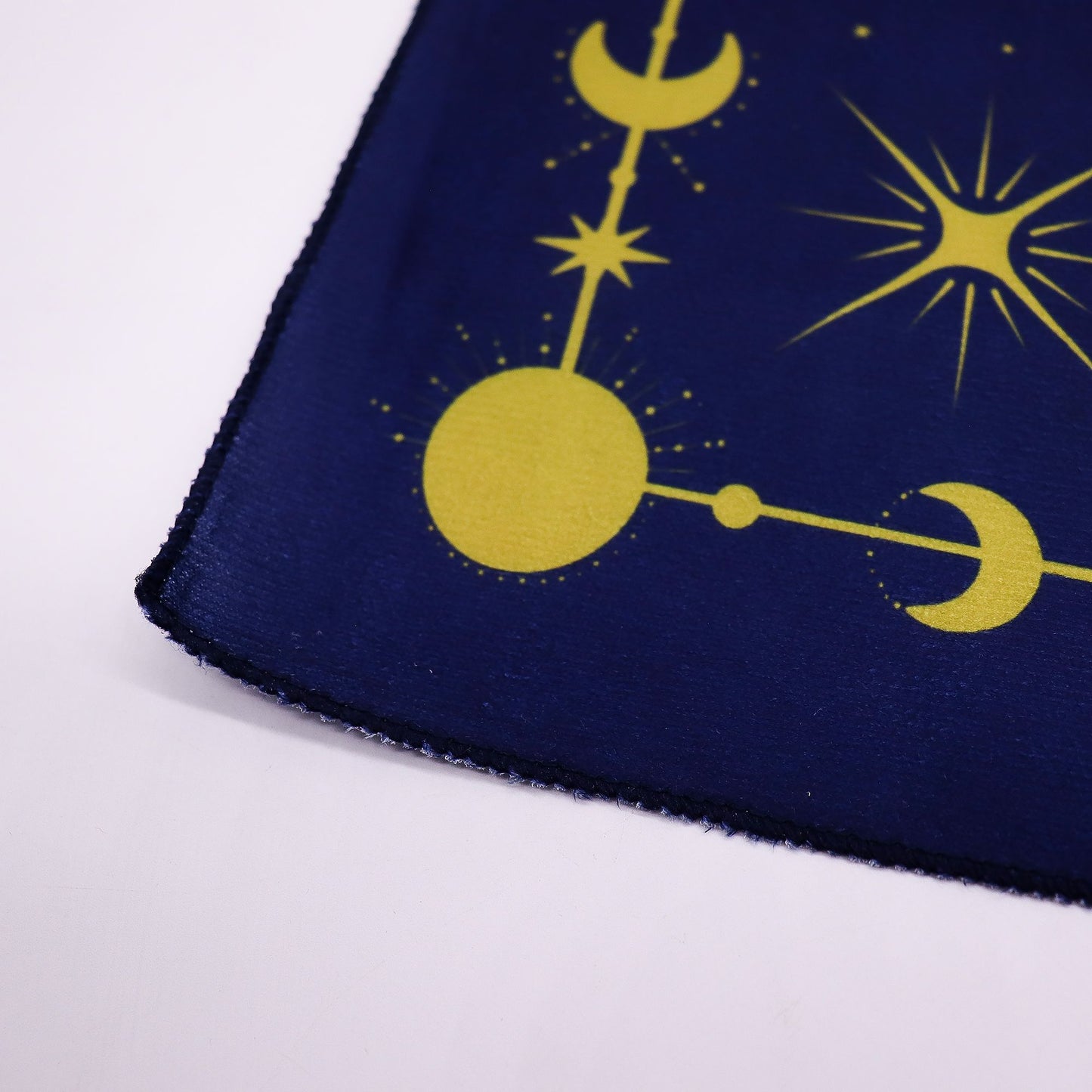 A dark blue tarot cloth with a yellow zodiac design.