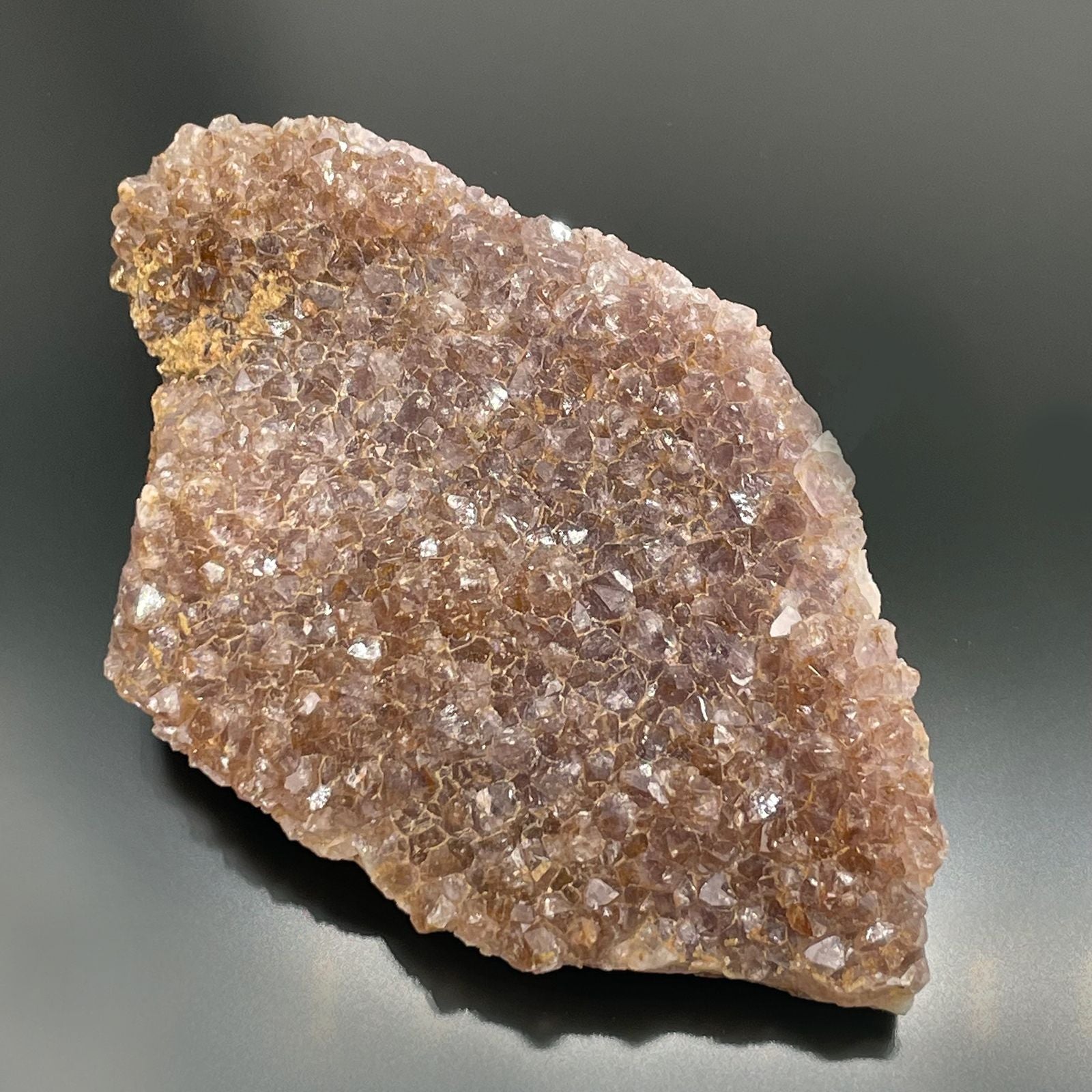 Ein flacher Rohamethyst mit vielen kleinen, violetten Kristallen.