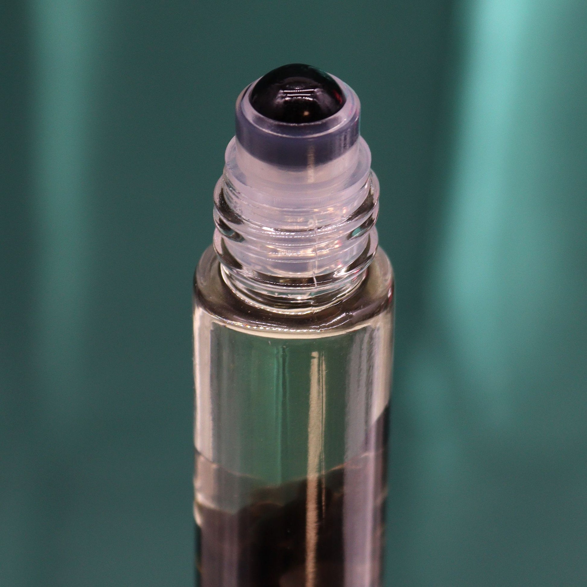 Roll-On Flasche mit schwarzem Stein und ätherischen Ölen.
