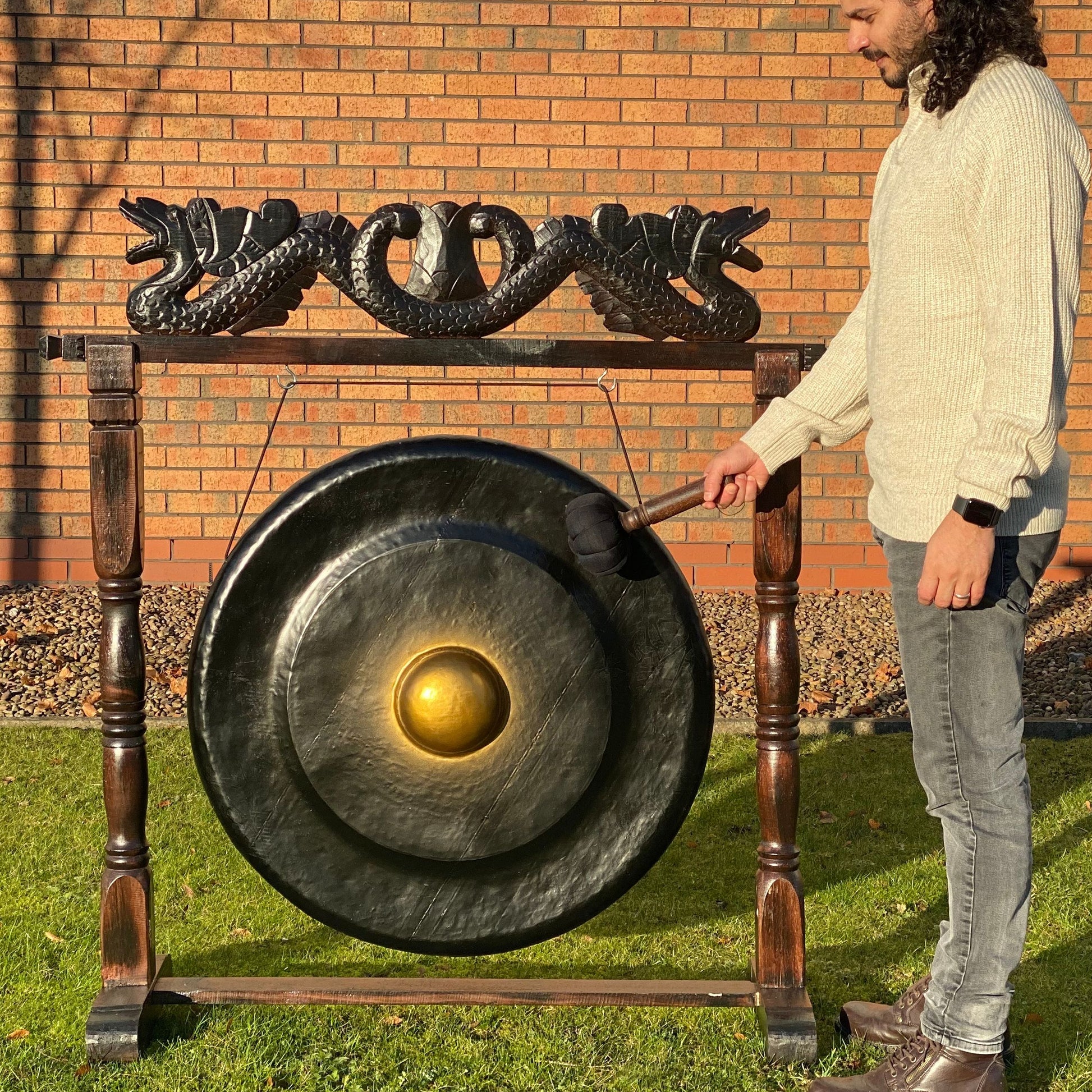 Handgefertigter schwarzer Heil-Gong mit 80cm Durchmesser und geschnitztem Holzständer.