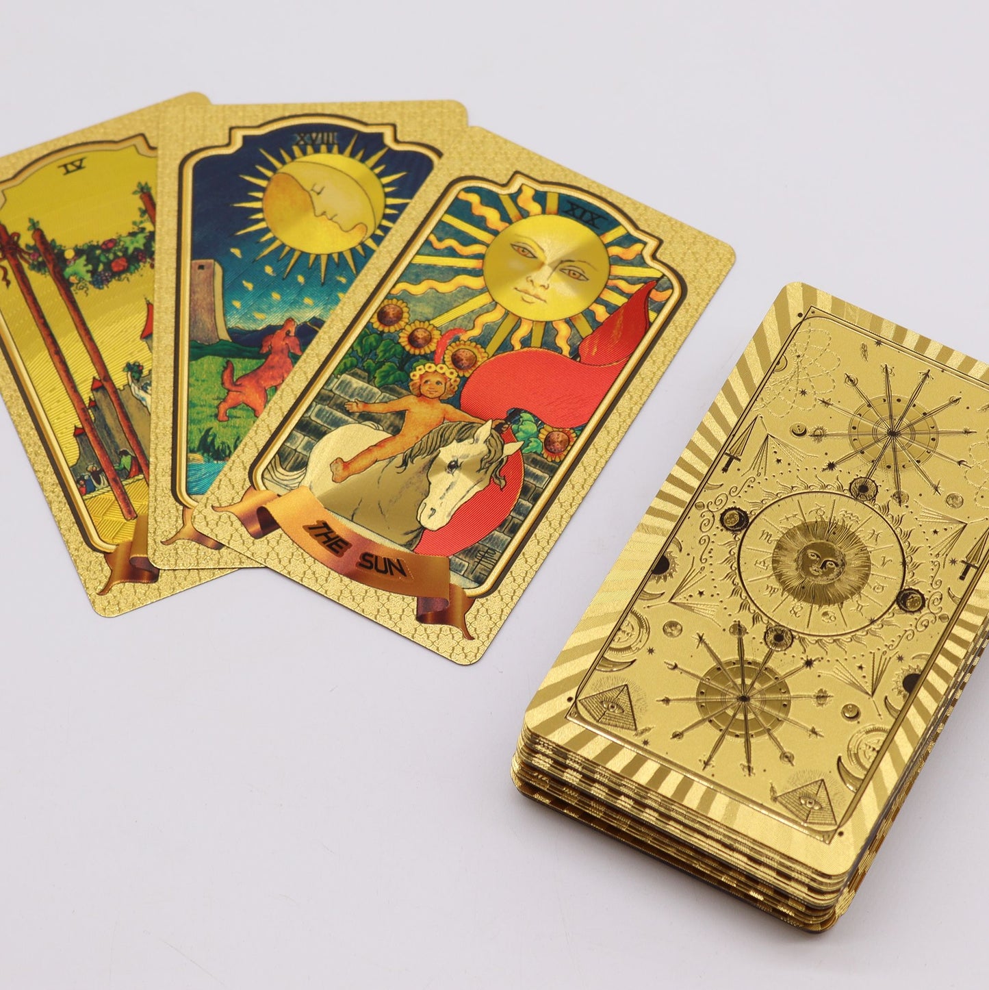 Goldene Tarotkarten mit klassischem Design und einem Stapel Kartenrückseiten.