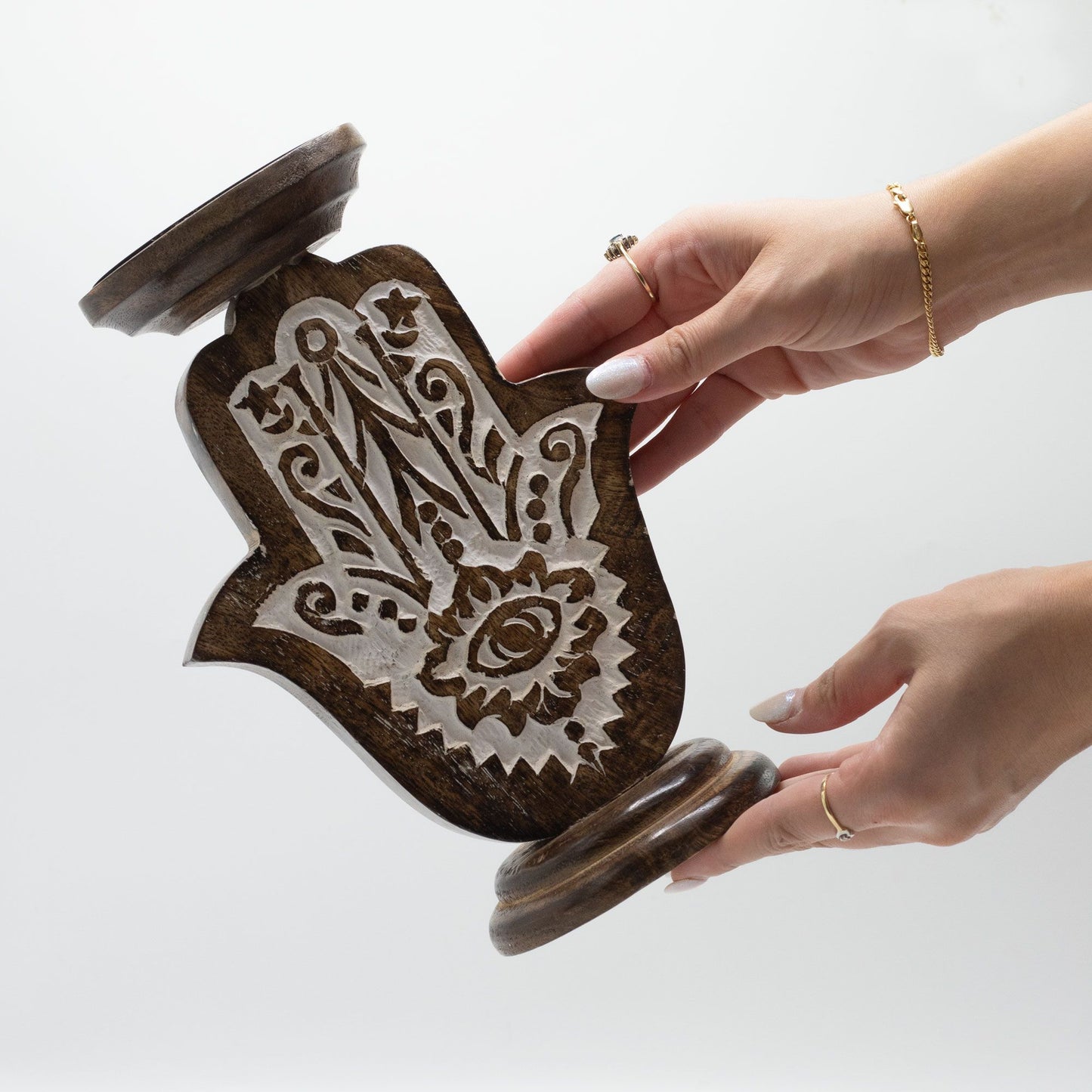 A large, carved mango wood Hamsa hand candle stand with intricate detailing.