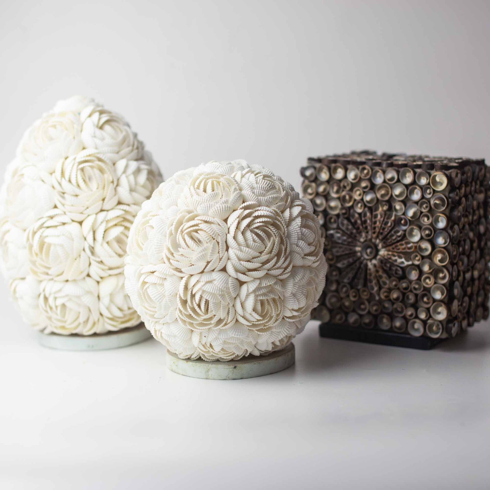 Oval lamp and spherical lamp decorated with white shells, and a square lamp decorated with brown shells.